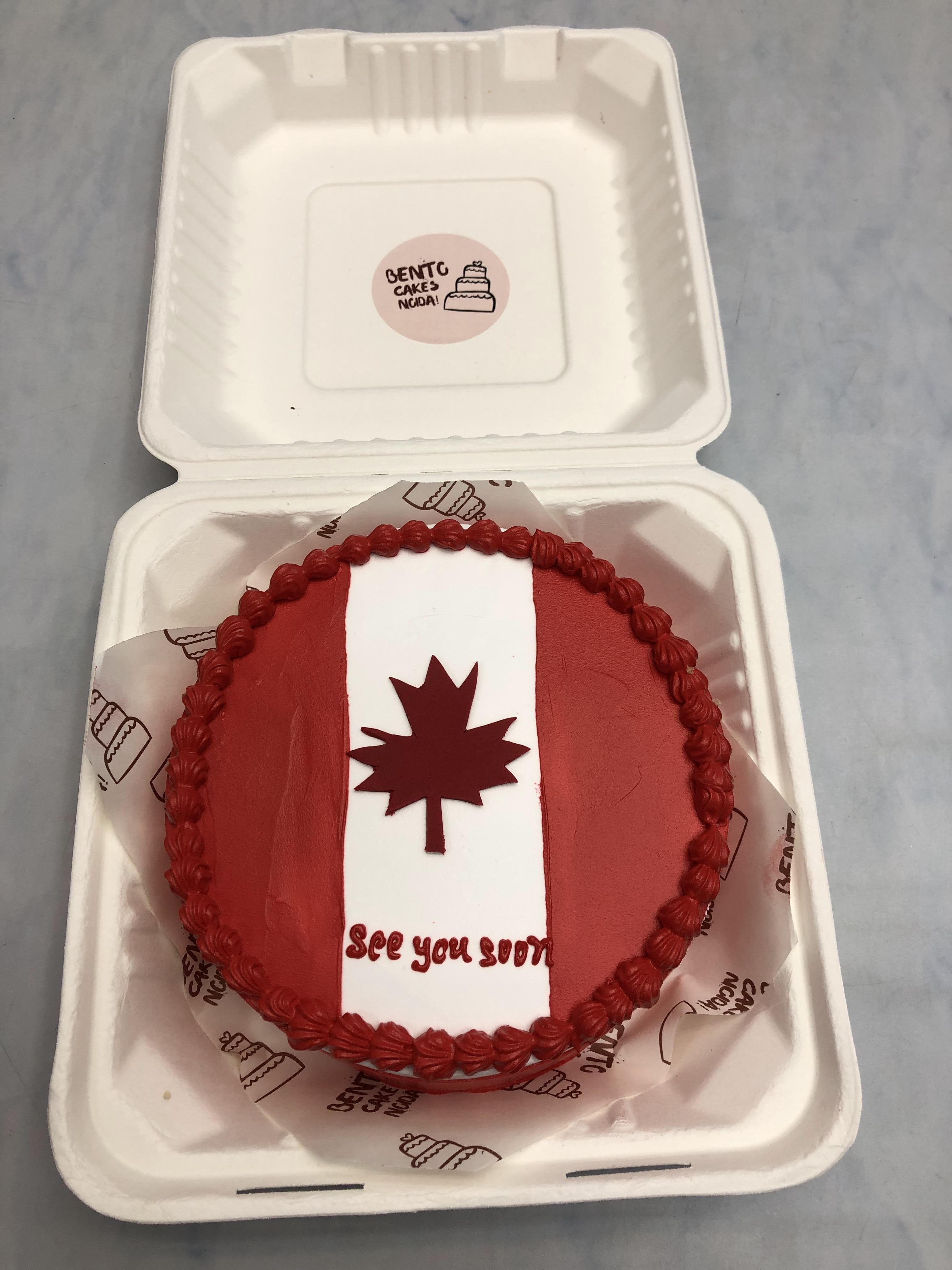 A dark red bento cake is designed on canada flag theme.