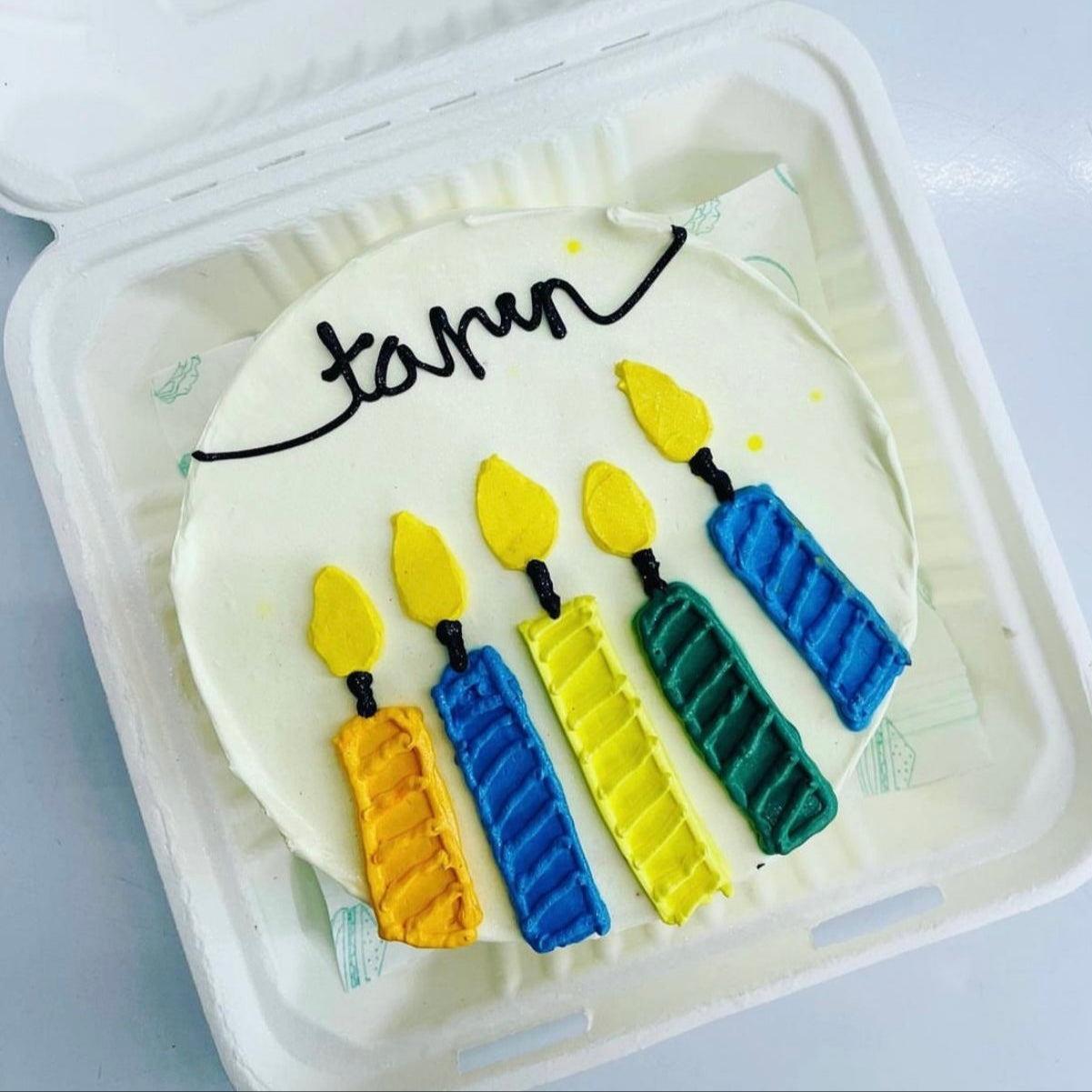 A decorated cake with lit candles design on cake top, ready for celebration.