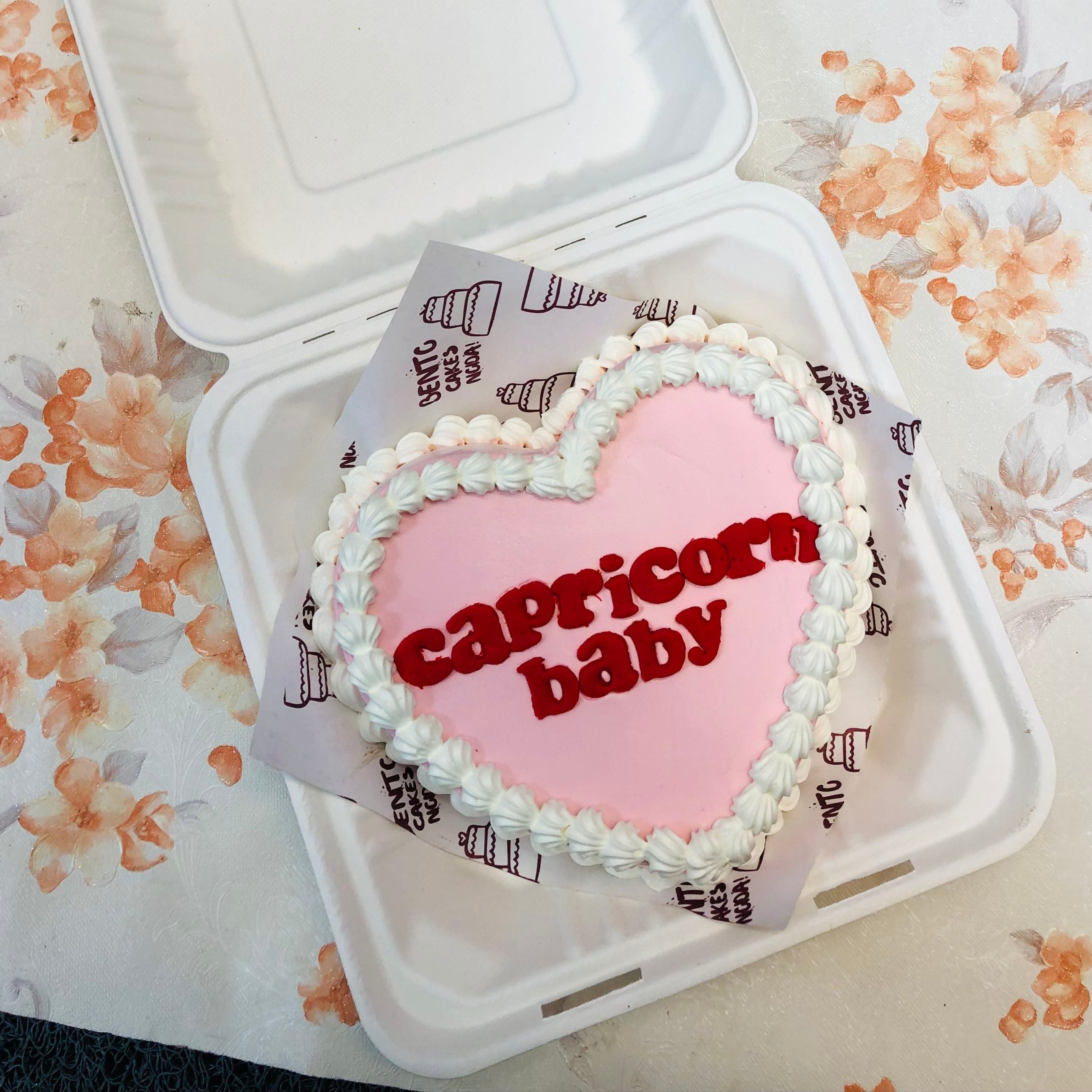 A Capricorn Baby theme ligh pink heart shape bento cake with white truffles on it.