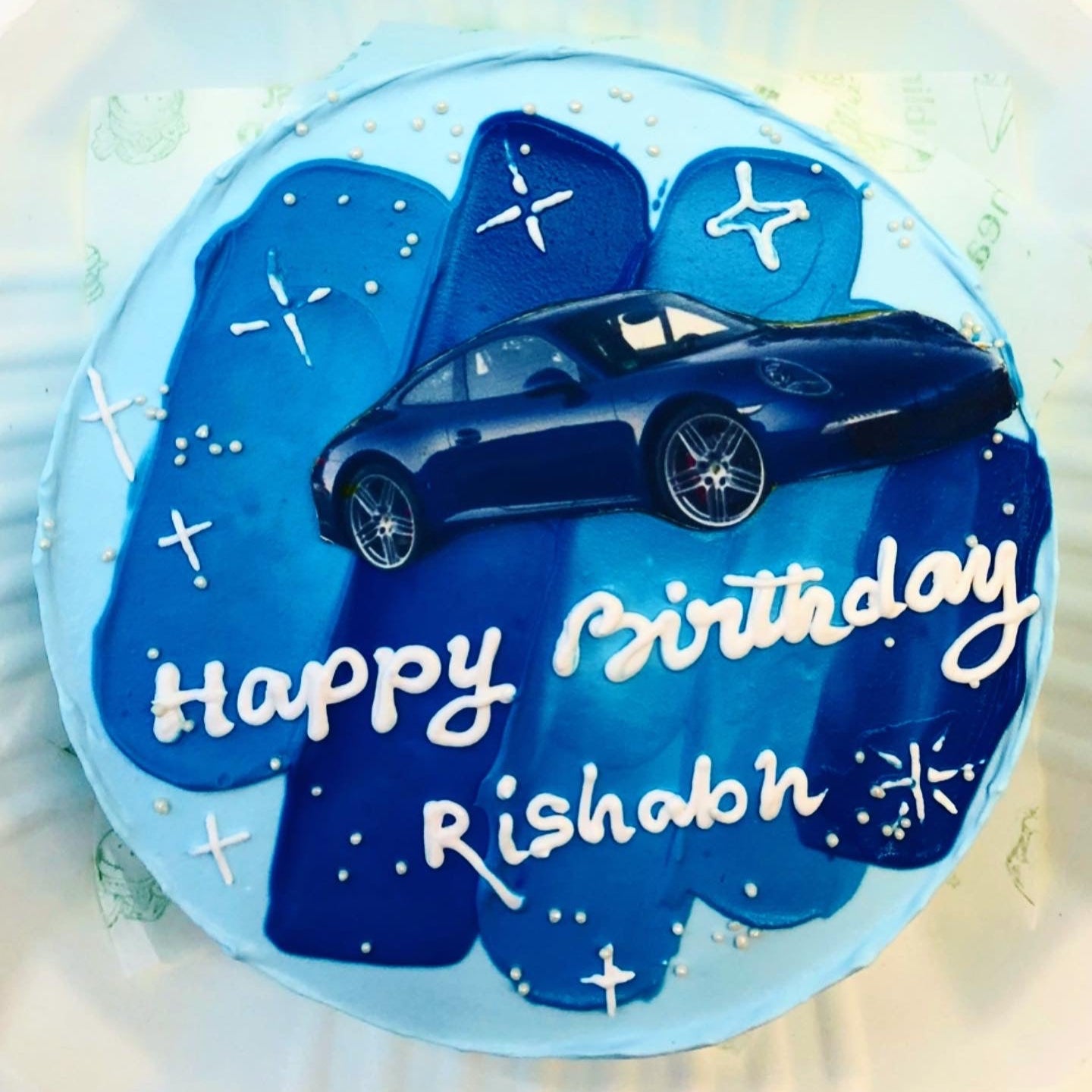 A colorful birthday cake adorned with a toy car, symbolizing joy and celebration for a birthday party.