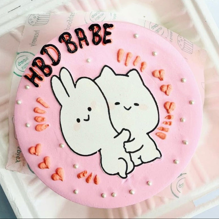 A pink cake adorned with two cartoon cats, creating a whimsical and delightful dessert scene.