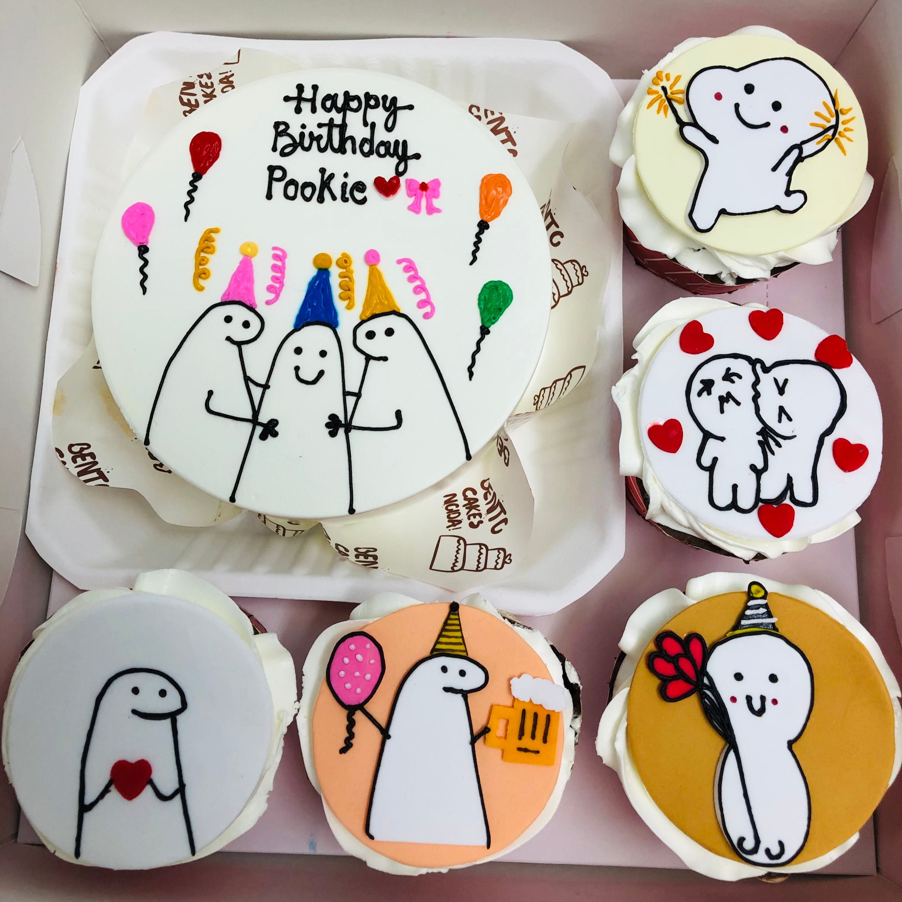 A set of birthday-themed cakes and cupcakes featuring cute, minimalist cartoon characters. The main cake has a "Happy Birthday Pookie" message with three characters wearing party hats, surrounded by colorful balloons and streamers. The cupcakes have various designs, including characters holding hearts, balloons, and beer mugs, as well as hugging and celebrating.