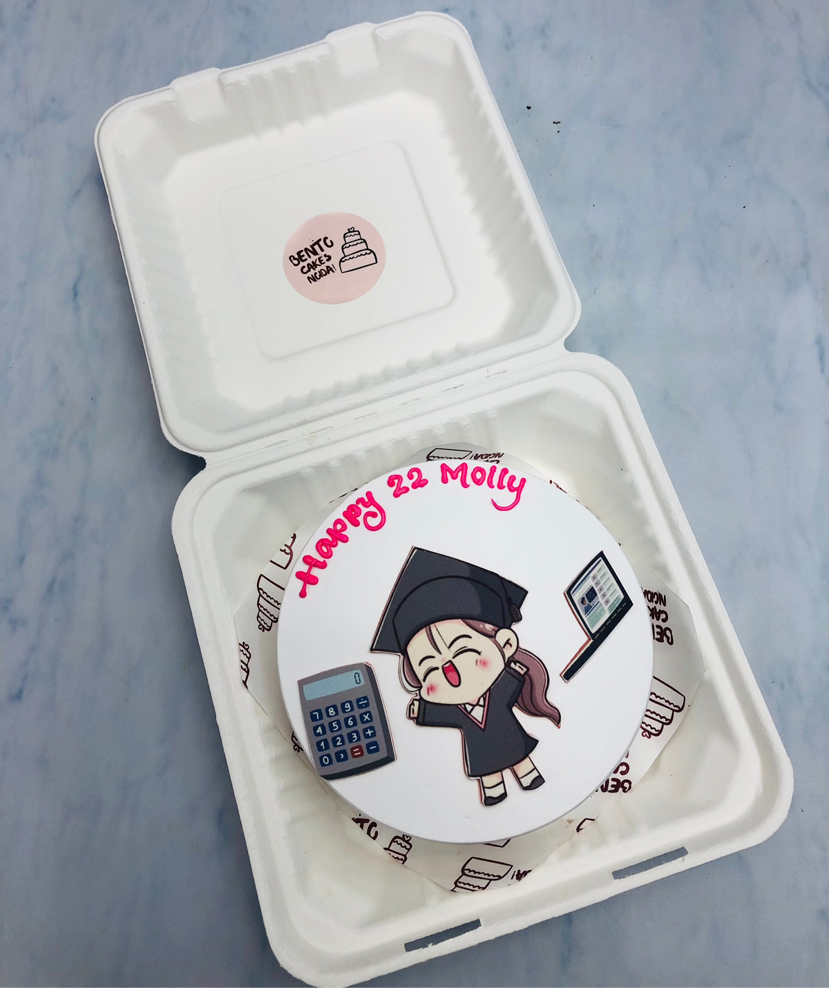 A white bento cake is designed for a girls 22nd bithday celebration, with Charter Accountant theme.