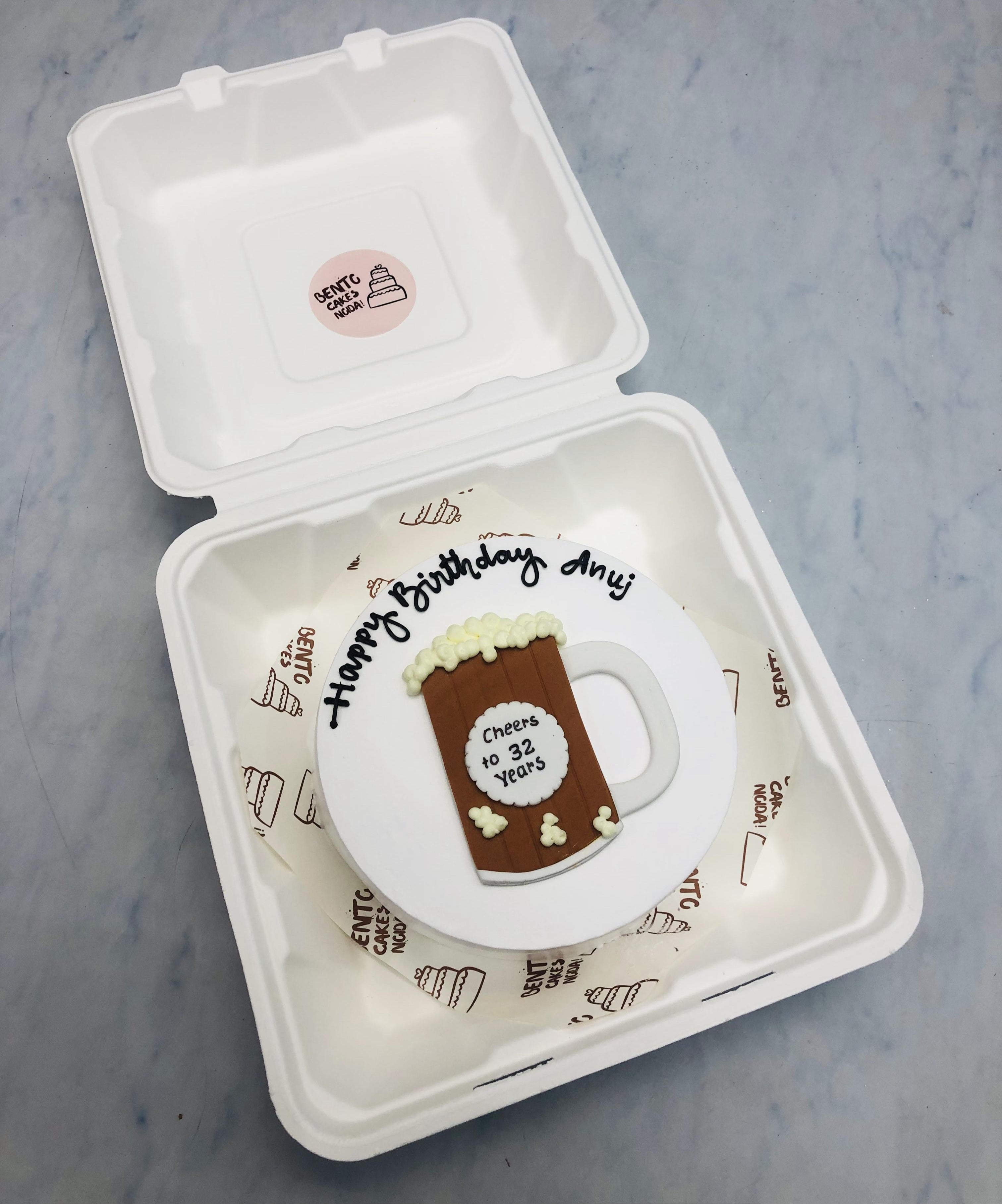 A white bento cake with a fondant bear mug design for Anju's Birthday.