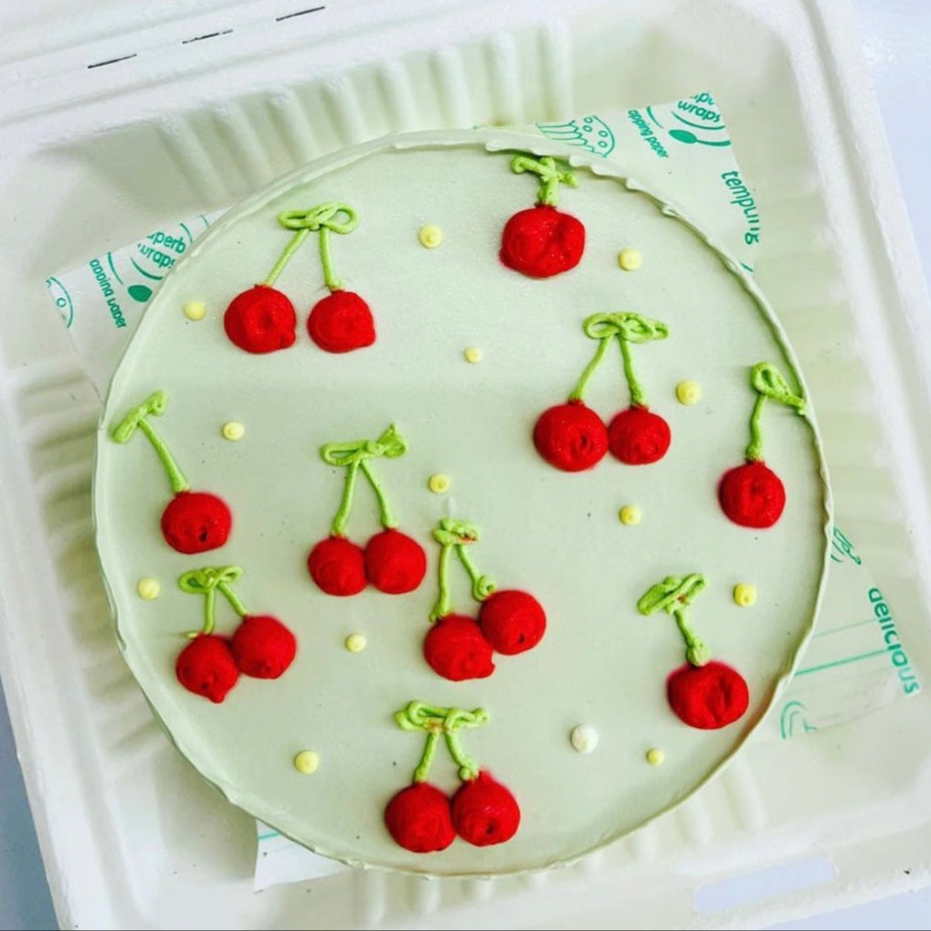 A delicious cake topped with fresh cherries design, displayed in a bento box, ready to be enjoyed.