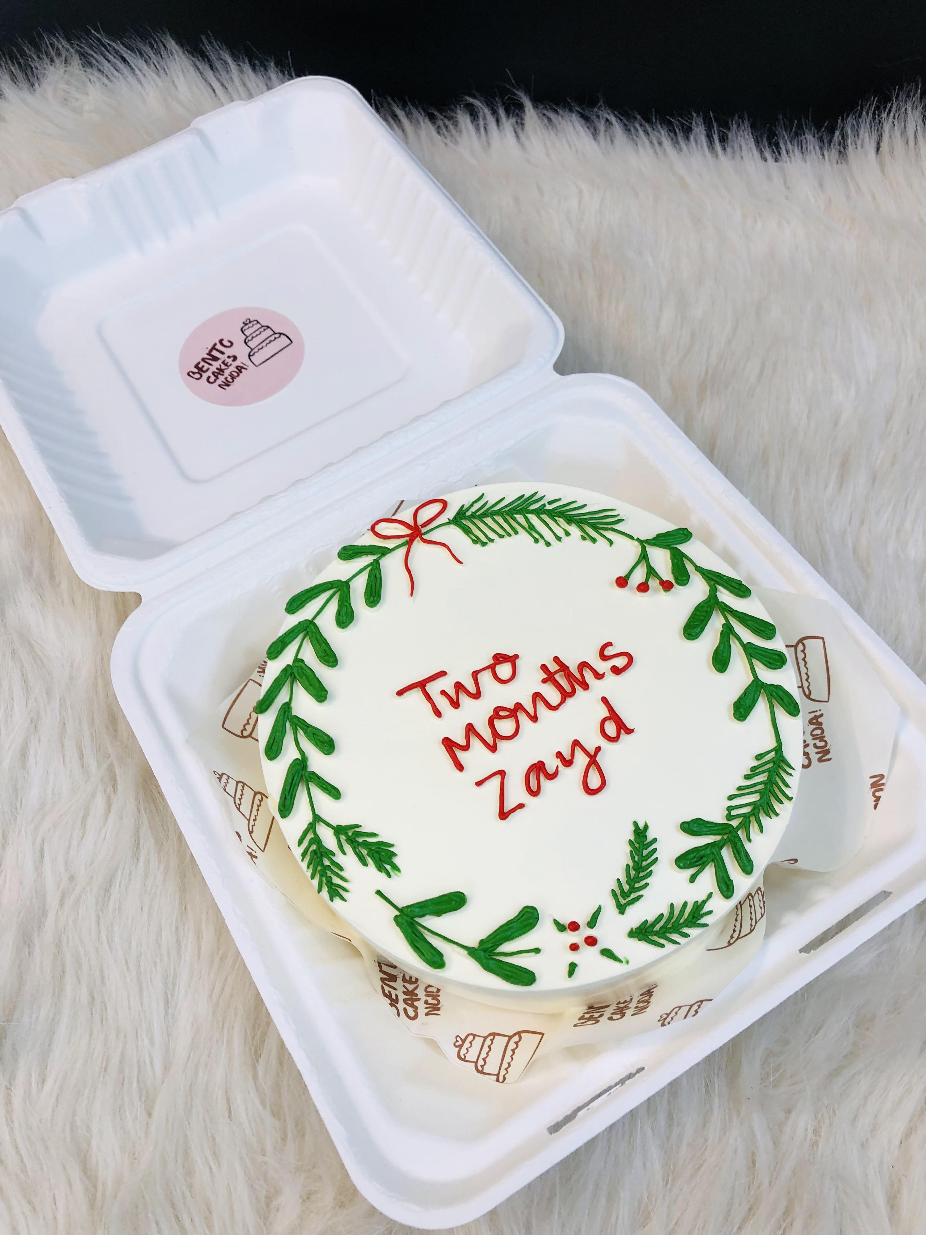 A white bento cake designed with christmas and 2 months baby birthday.