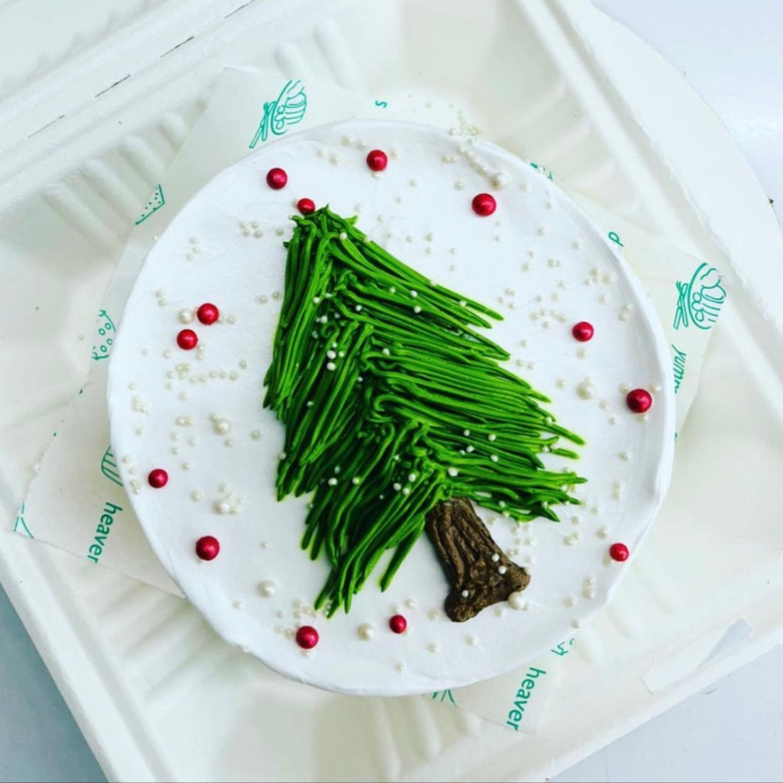 A unique Christmas tree crafted from green beans, elegantly displayed in a white box.