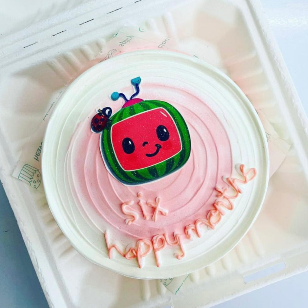 A delightful cake in a box featuring a cheerful cartoon character on top, perfect for any celebration.