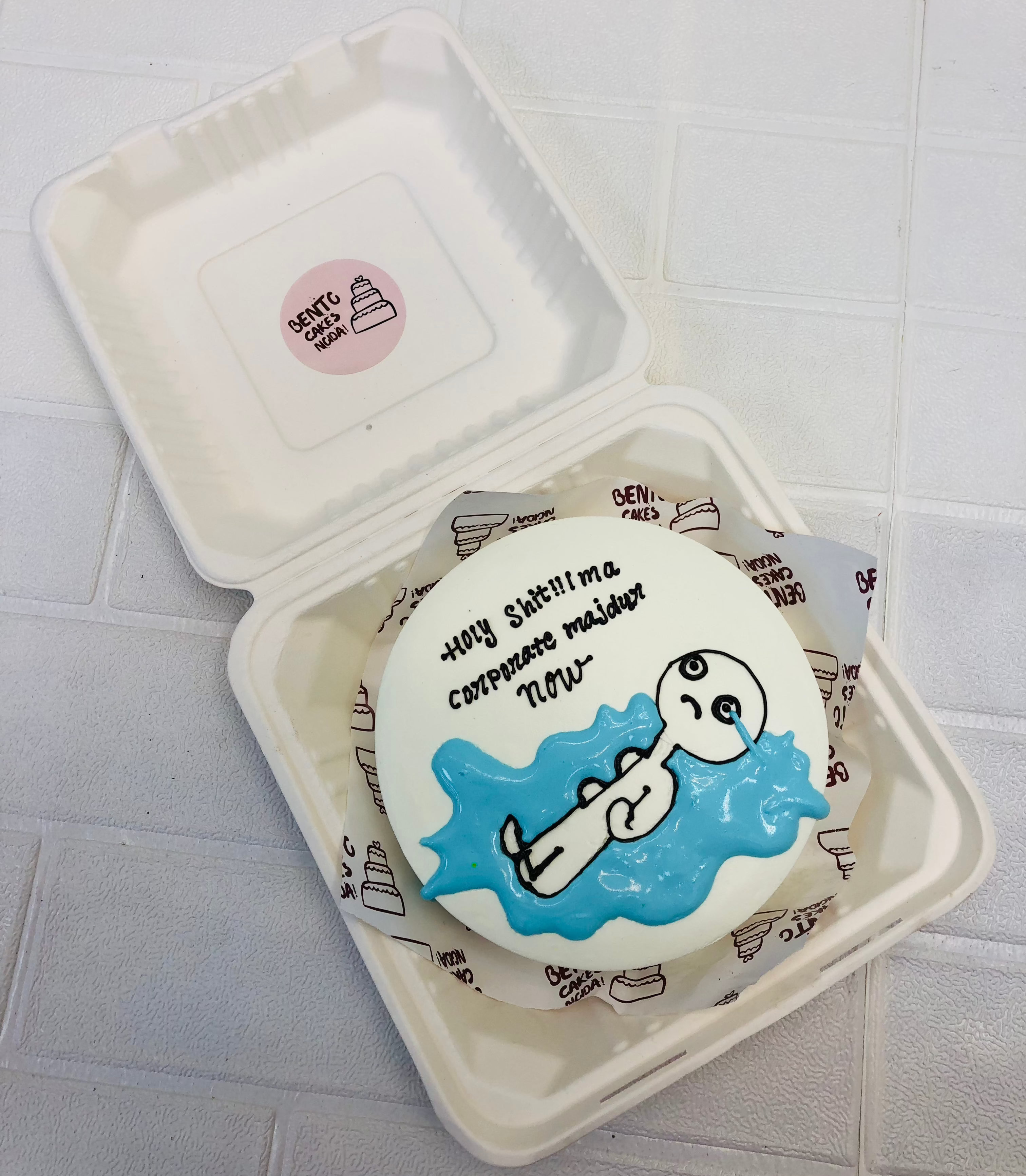 A white bento cake showing a weeping cart on theme with a "Corporate Majdur" text on it.