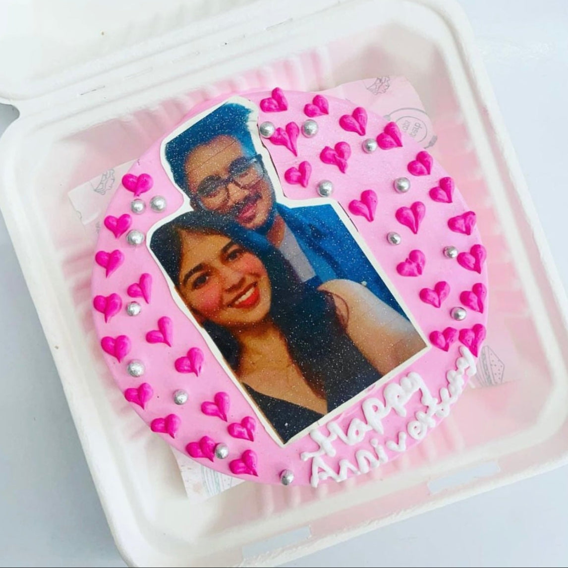 A delightful bento cake featuring a couple's photo on top, perfect for commemorating a romantic occasion.