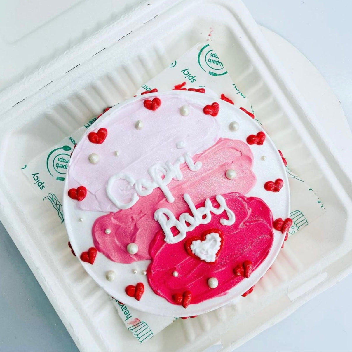 A beautifully crafted cake featuring the words "capri baby" artistically displayed on top.