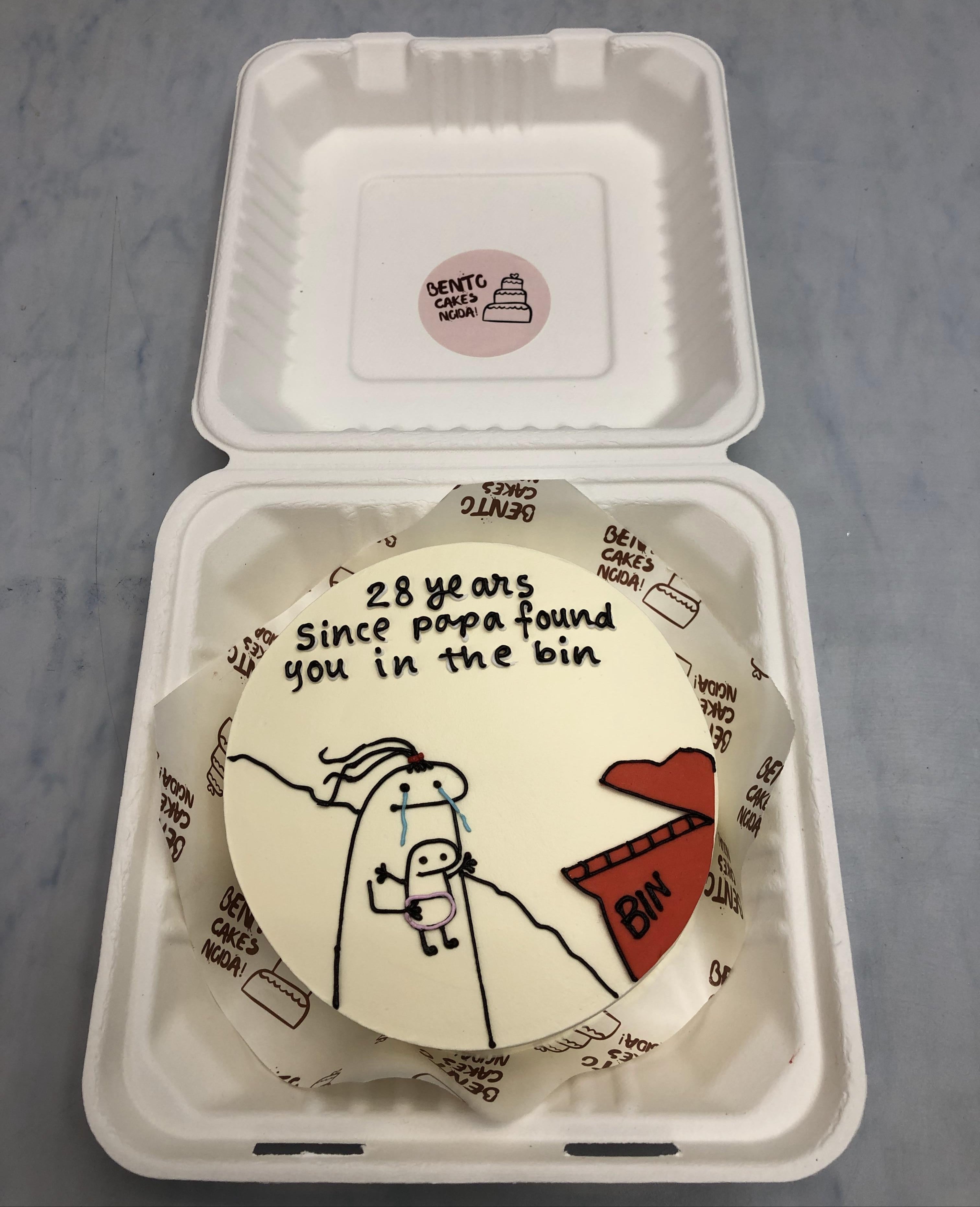 A white bento cake having a funny mimi cartoon with funny text written on the cake.
