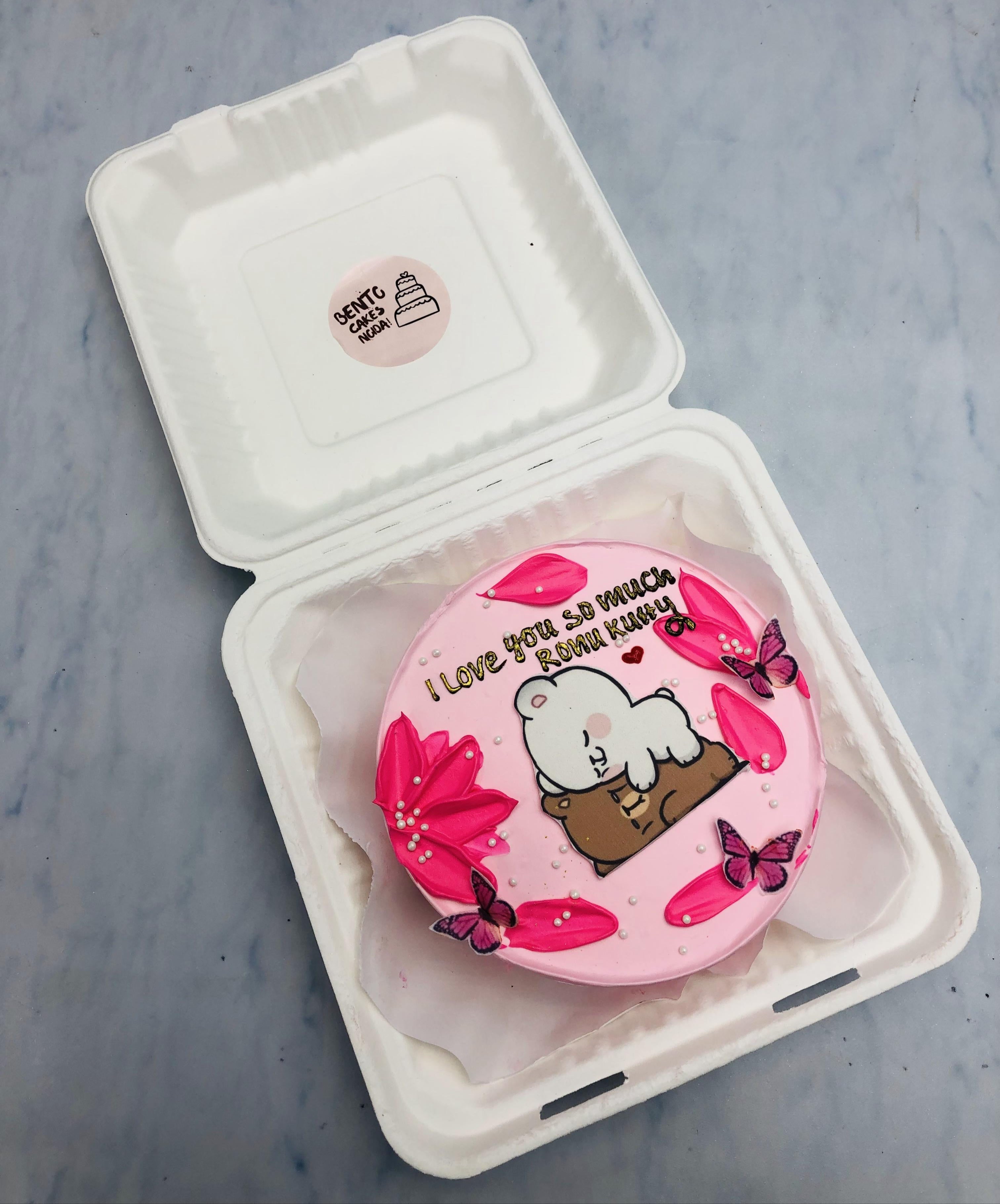 A pink floral design bento cake with sleepy bbu dudu print on it.