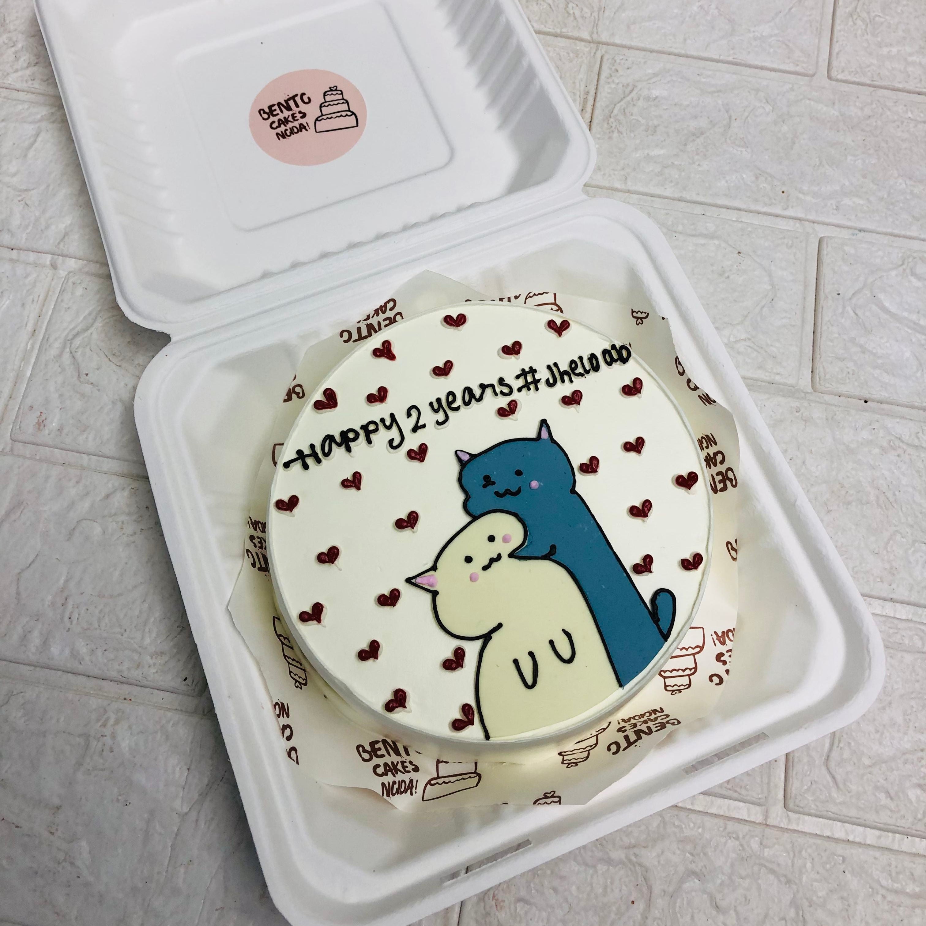 A cake in a bento box featuring a colorful cartoon character design on top.