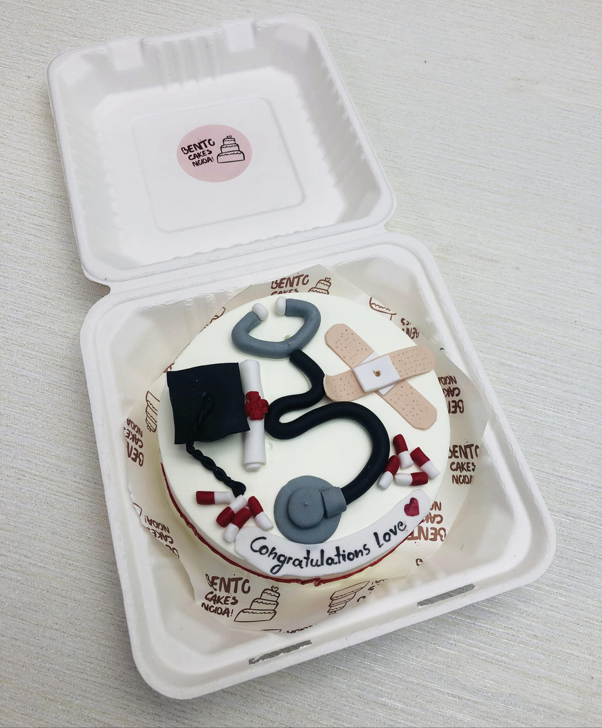 A white bento cake designed for doctors birthday with doctor's fondant kit.