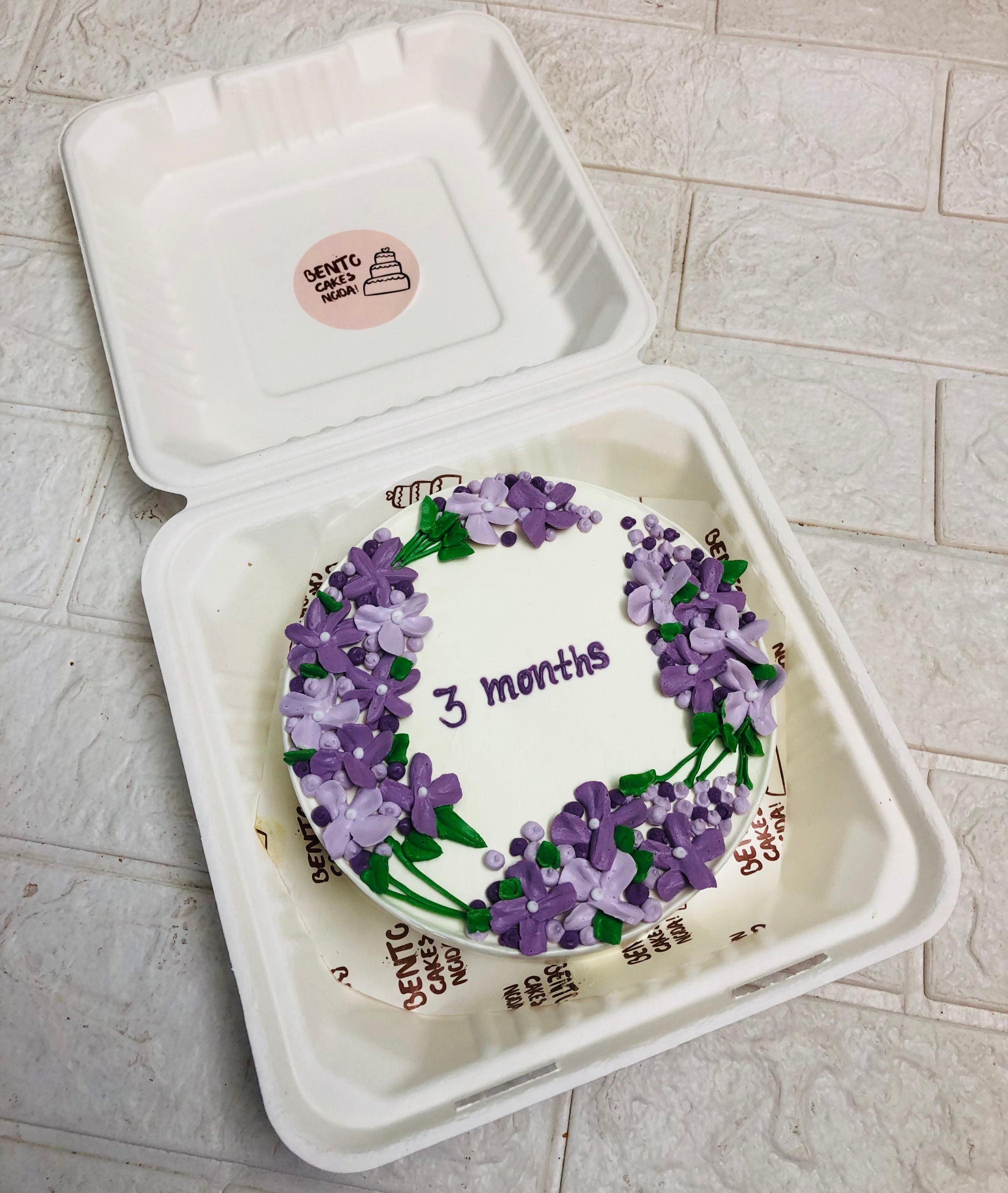 Full of purple florals design on white bento cake for celebrating 3 months.
