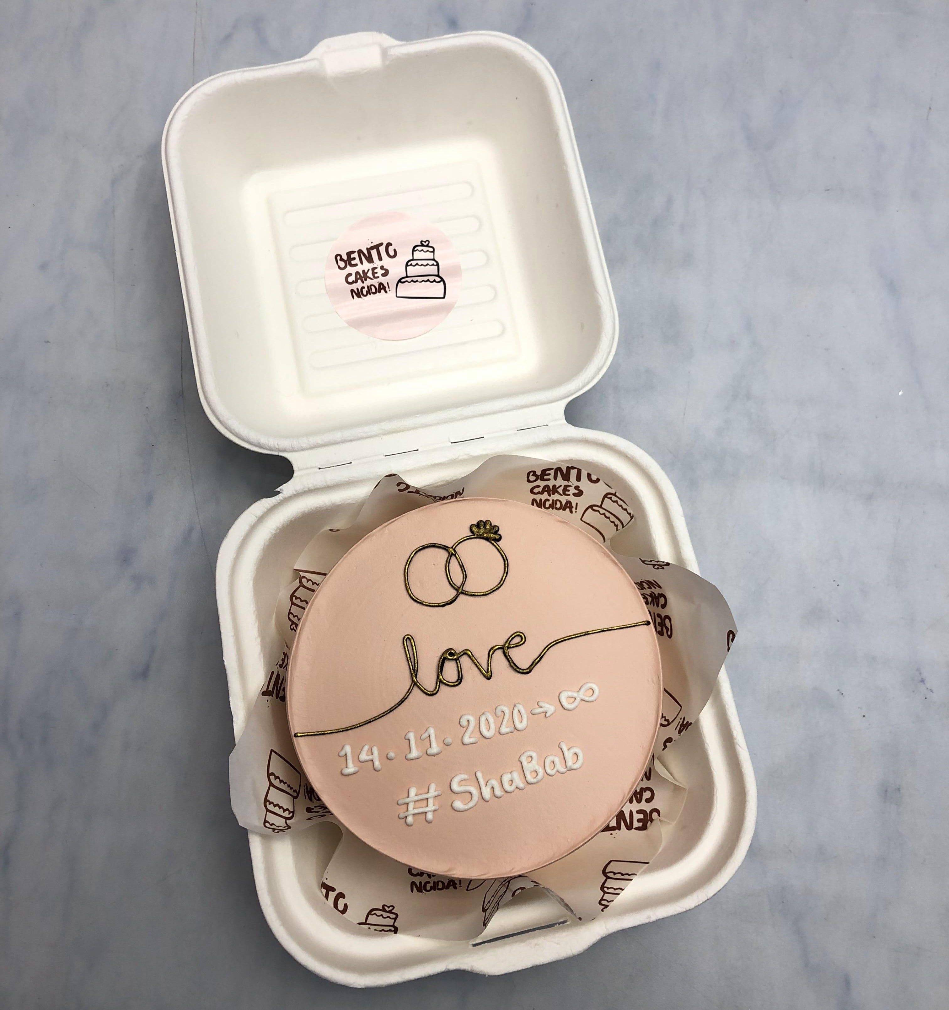 A peach color mini bento cake is designed for engagement occasion.