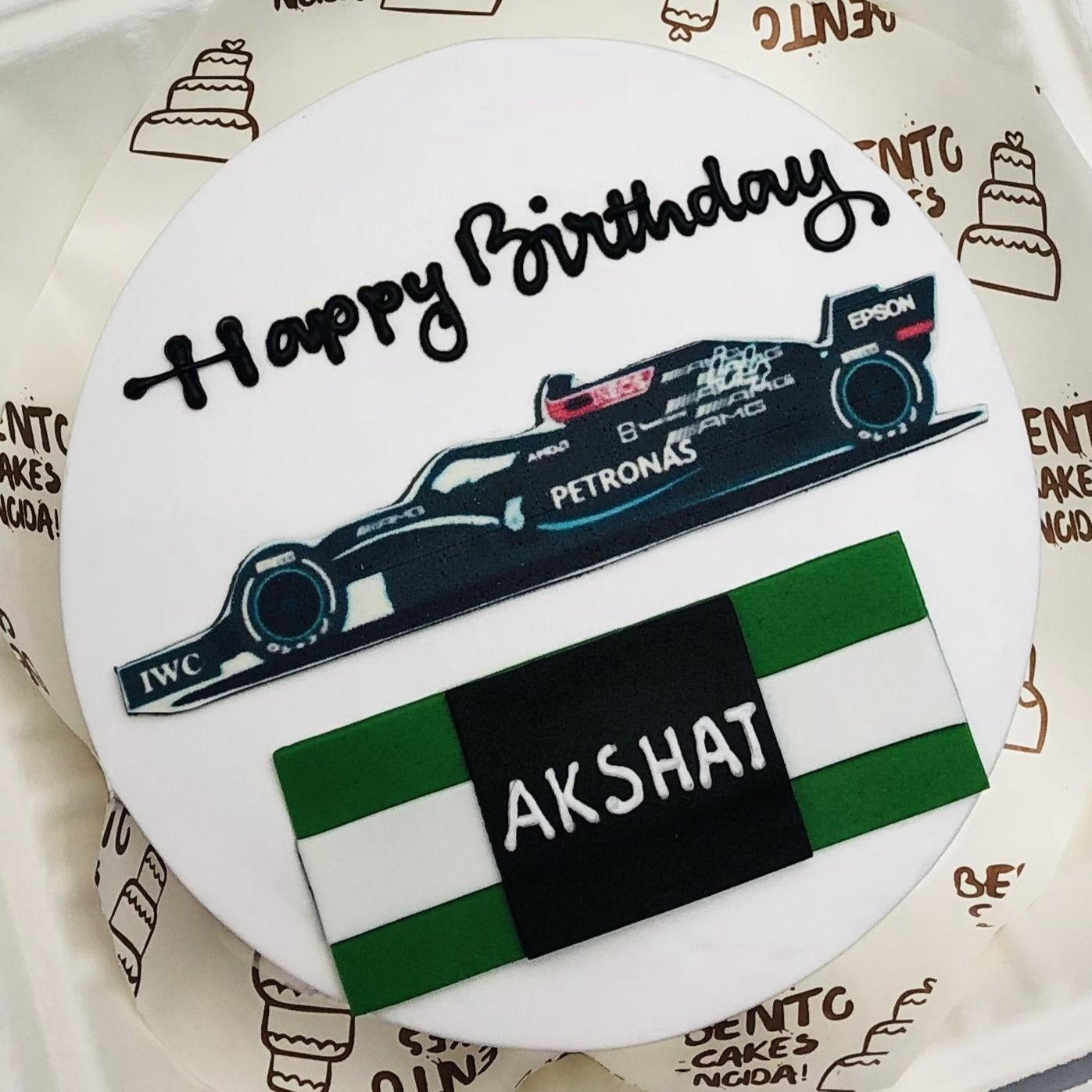 A white bento cake having F1 car print on it.