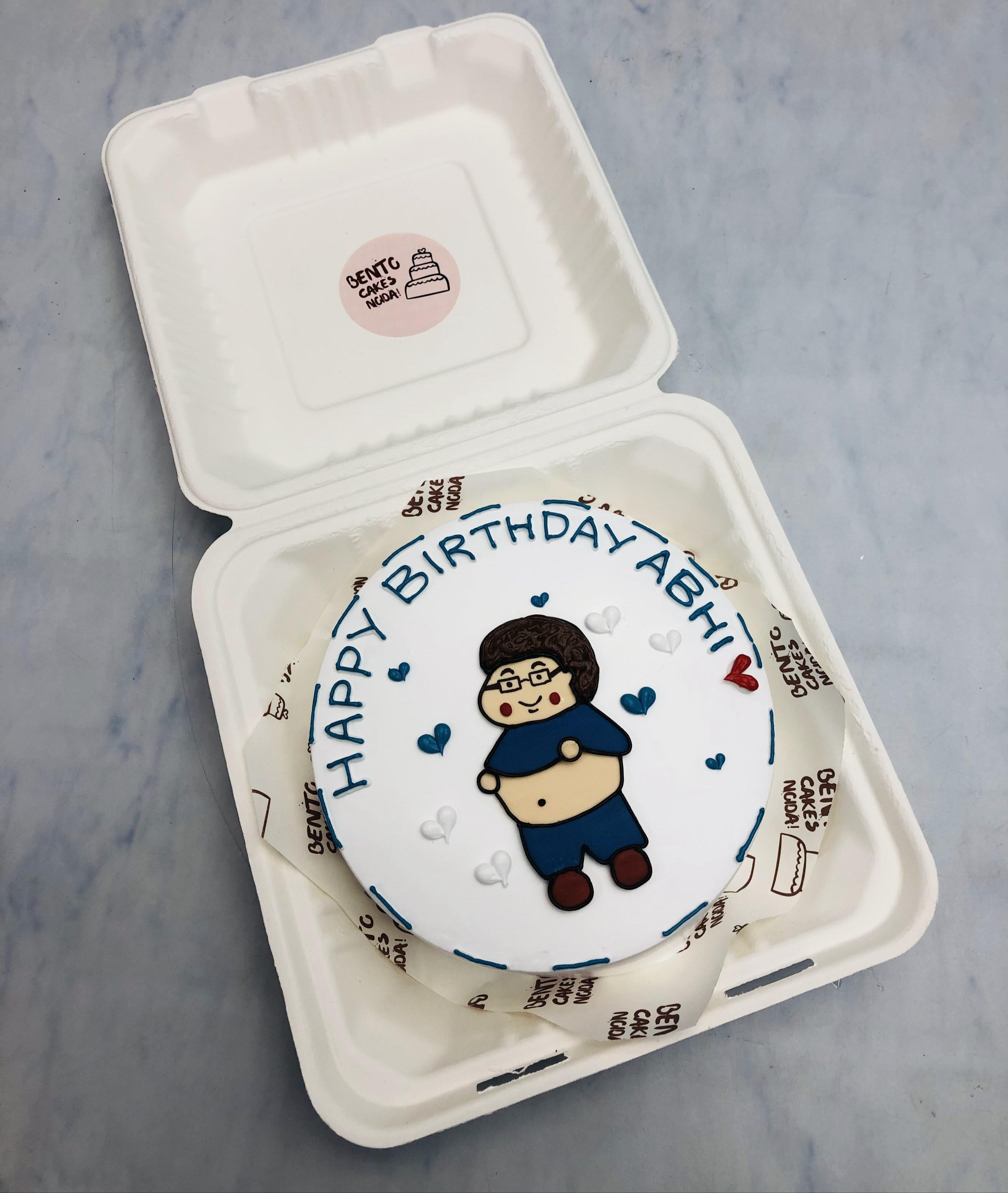 A white bento cake with a fatty man design showing his stomach and enjoying his birthday.