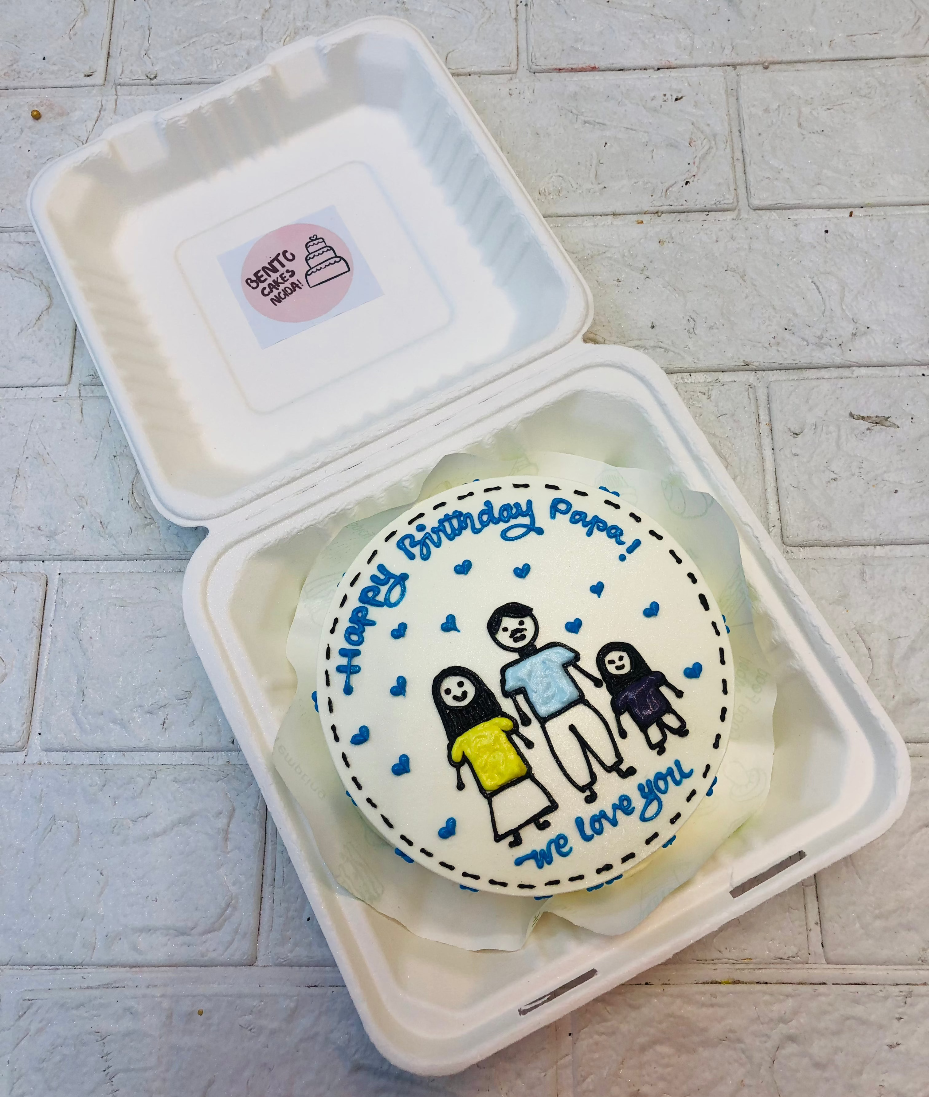 A beautifully crafted birthday cake featuring a hand-drawn family illustration and a heartfelt message, presented in a bento box—perfect for a personalized celebration.