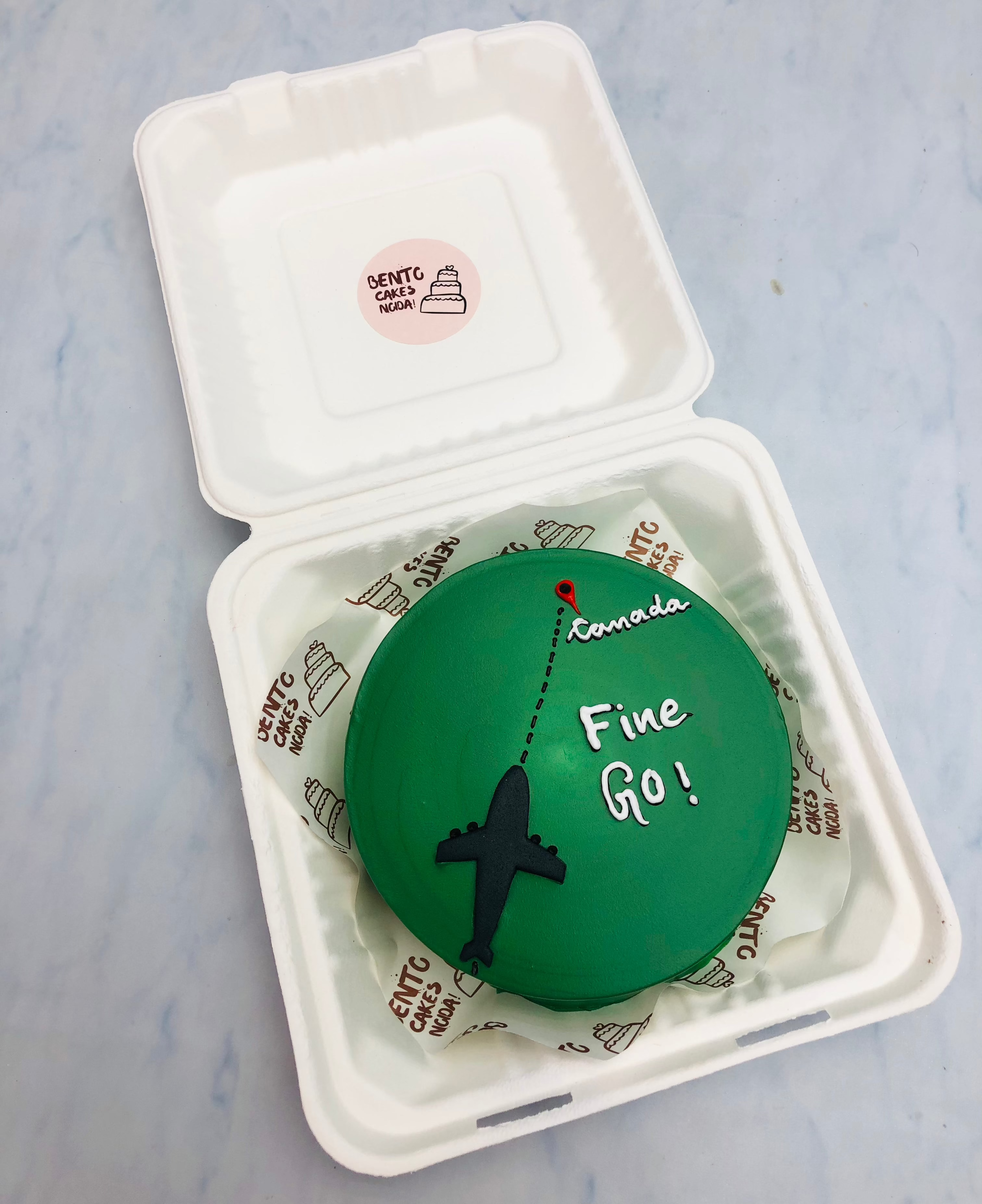 A dark green bento cake is designed for flight to canada and have safe journey.
