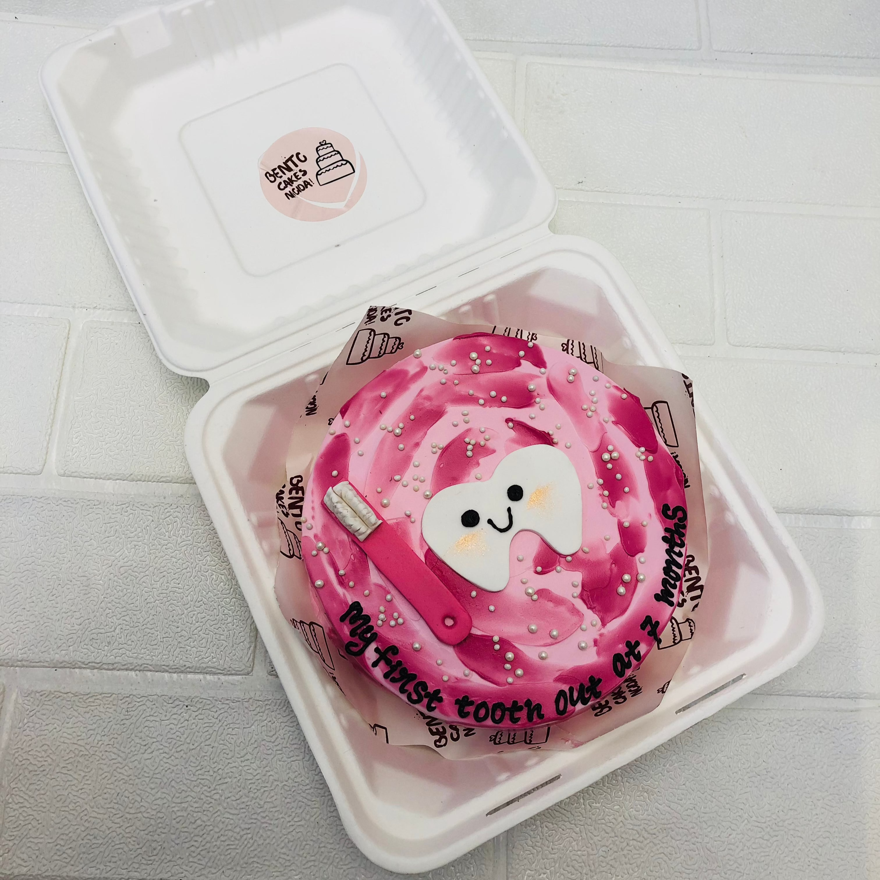 A pink bento cake with firt tooth theme.