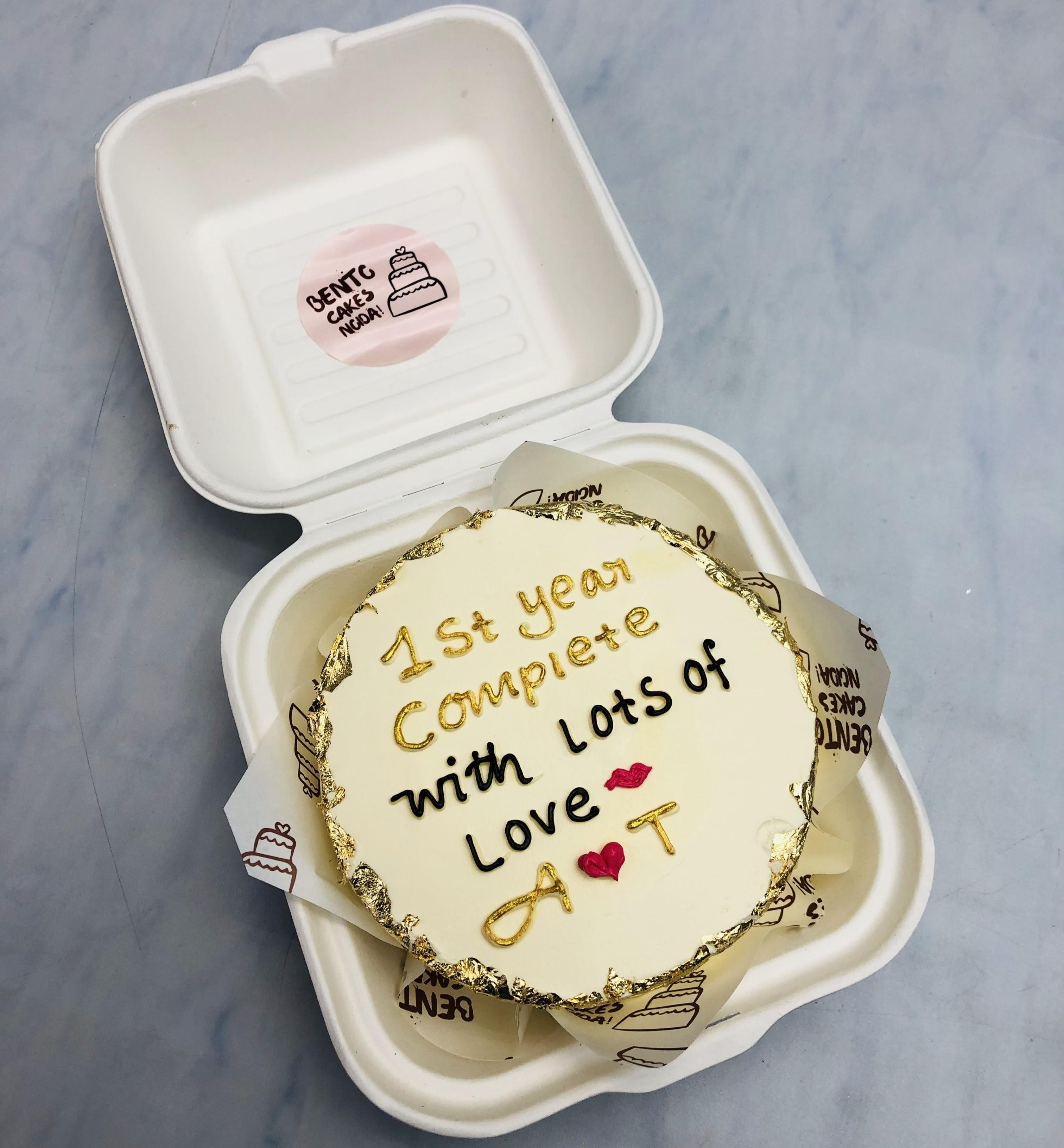 A lovely offwhite mini bento cake designed for 1st anniversary.