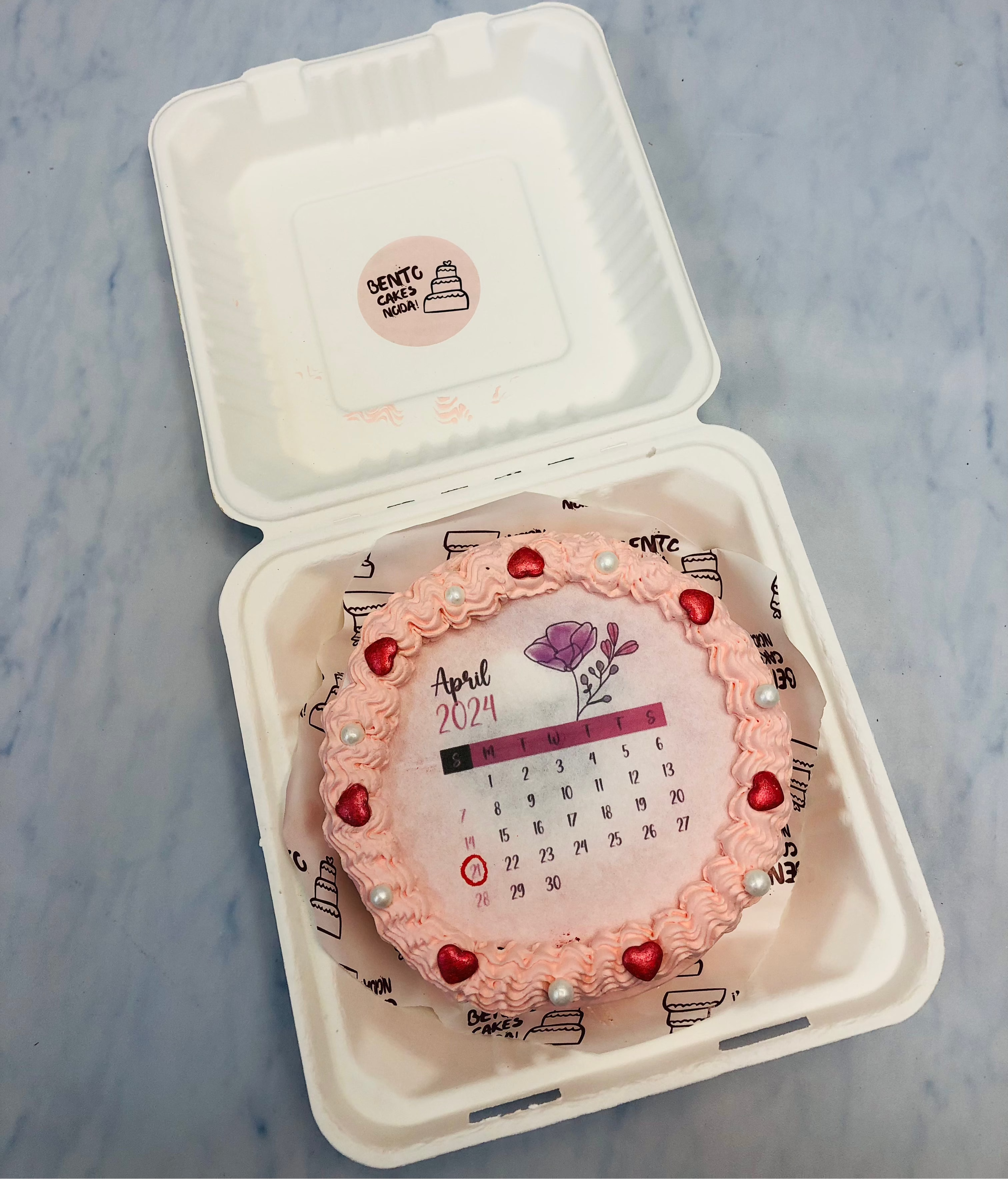 A peach color floral design fire bento cake with calendar theme.