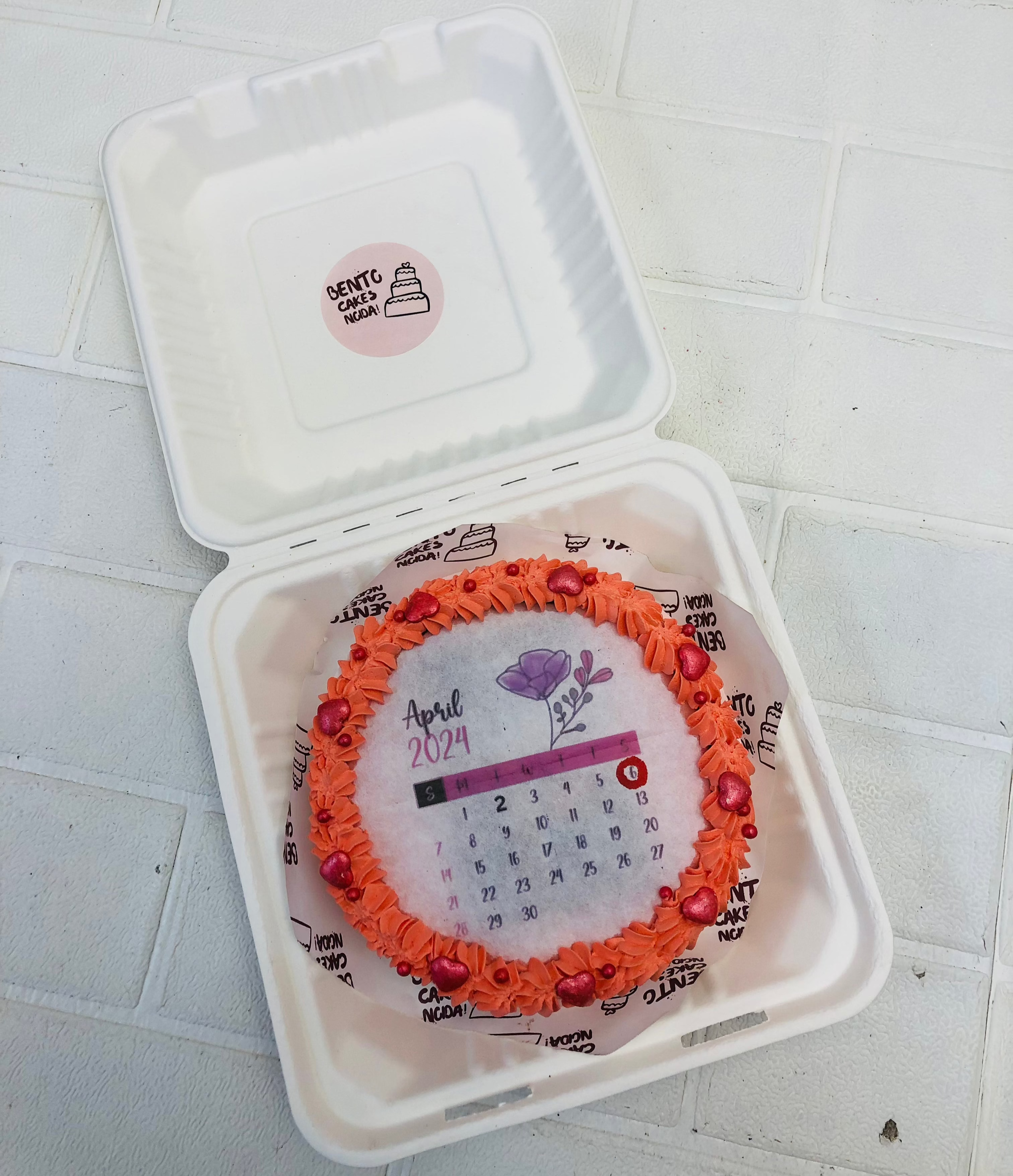 A Orange floral design on a calendar theme fire bento cake.