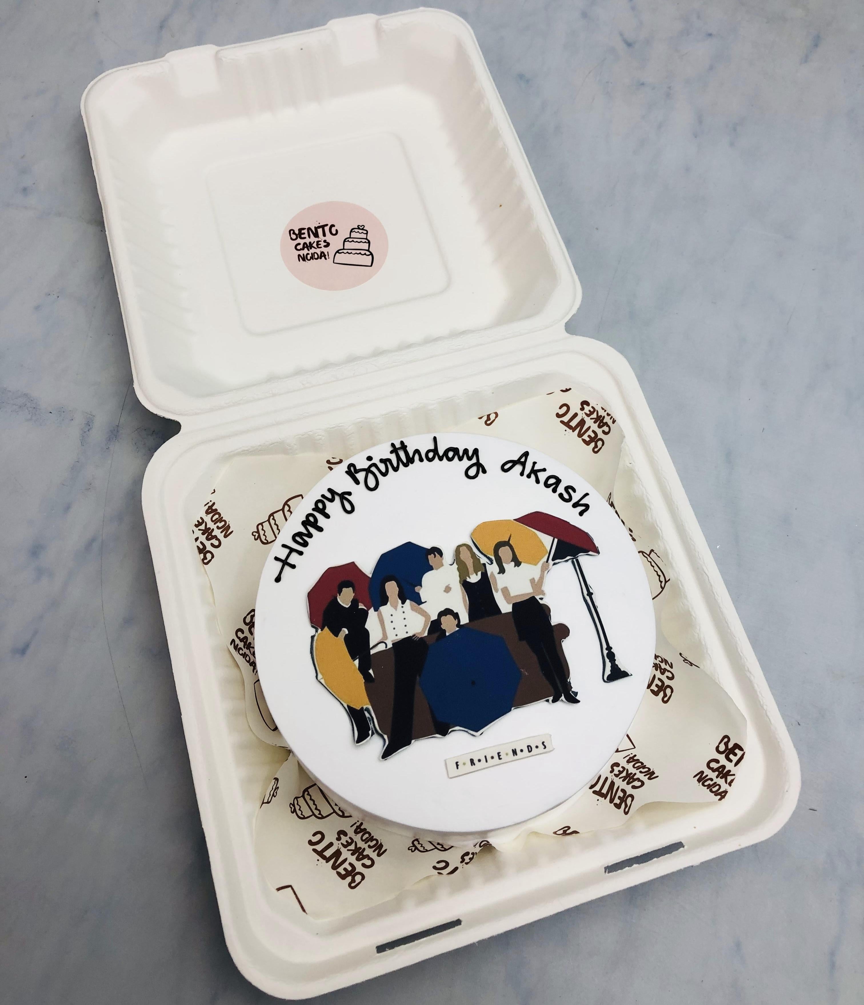 A white bento cake with a popular friends tv show print on it and it designed for friends birthday.