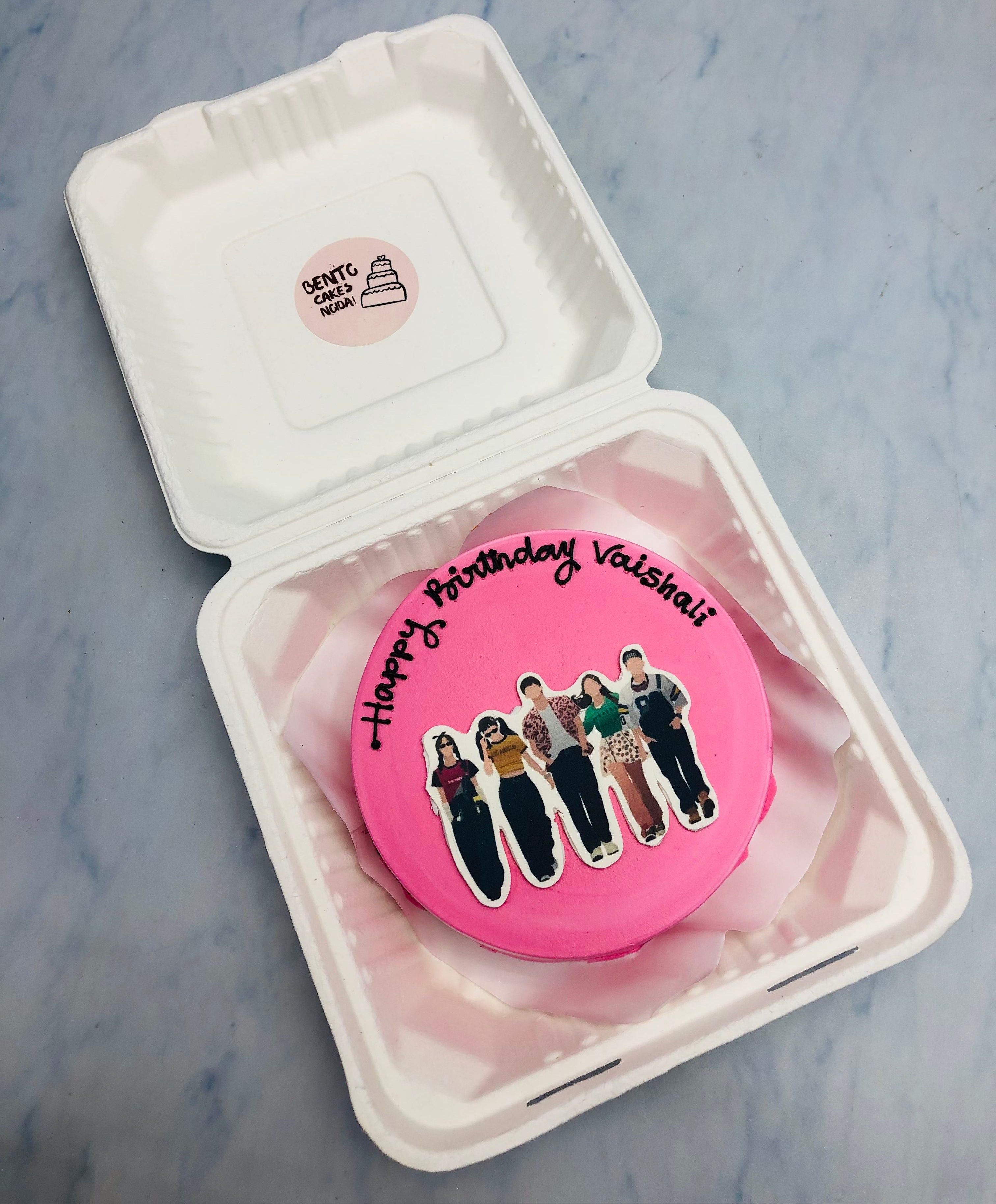 A lignt pink bento cake with friends group print.