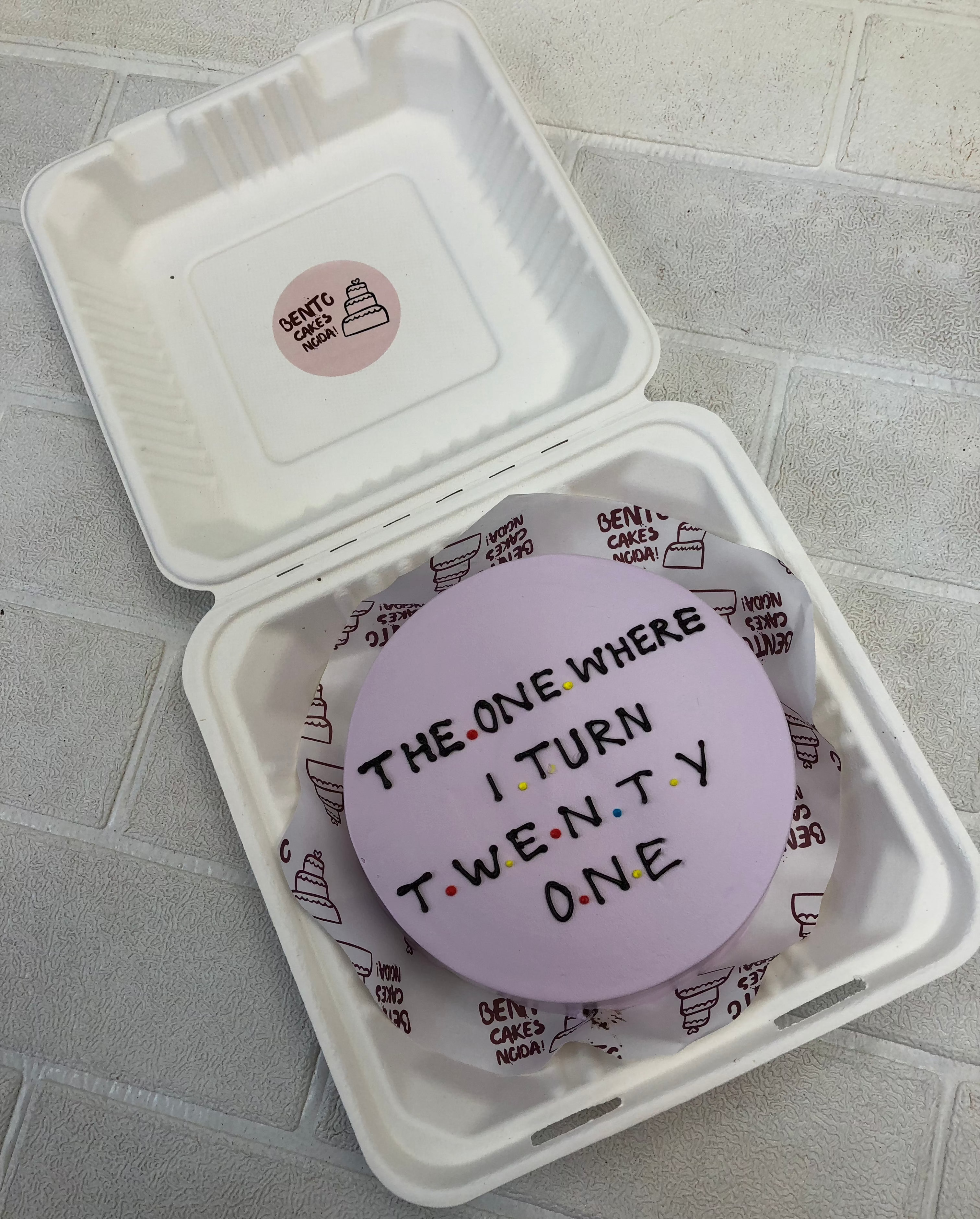 A light purple bento cake having a text written for 21 birthday.