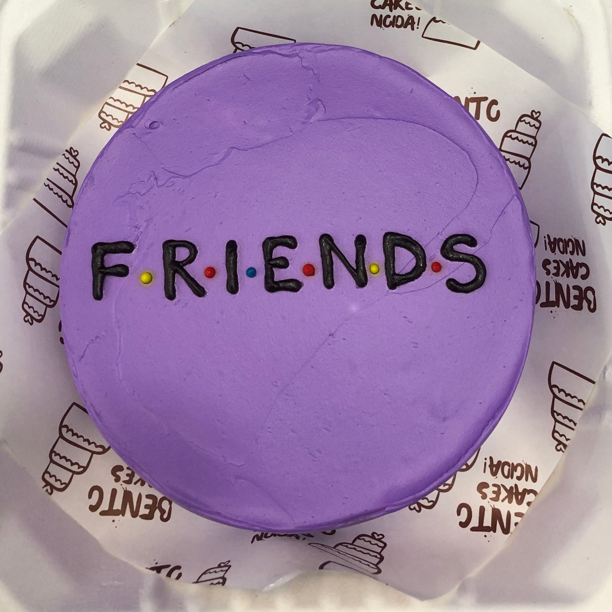 A purple bento cake having a popular tv show deisgn FRIENDS text written on it.