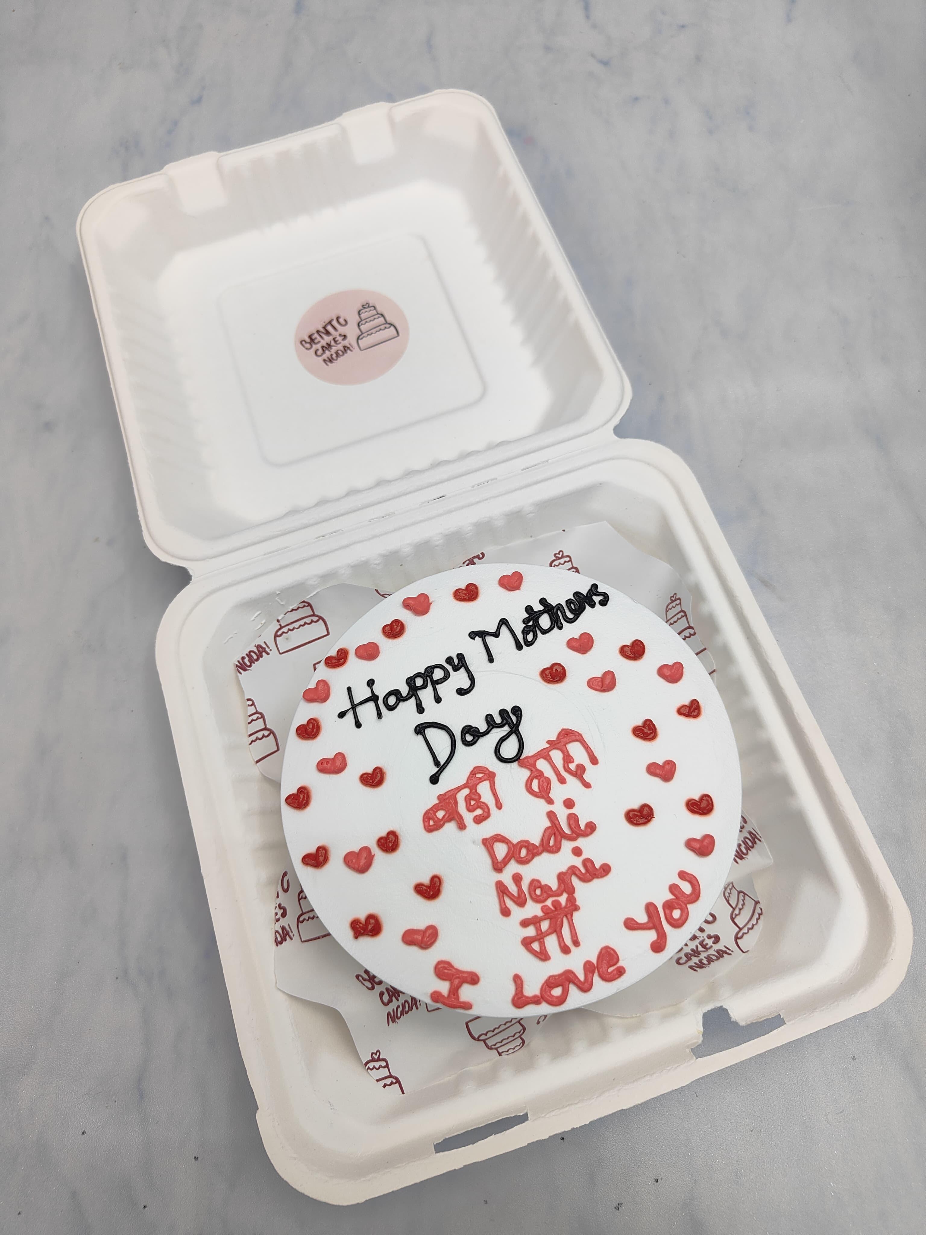 A white cake with red and pink hearts all over the cake and a loving text written on it.