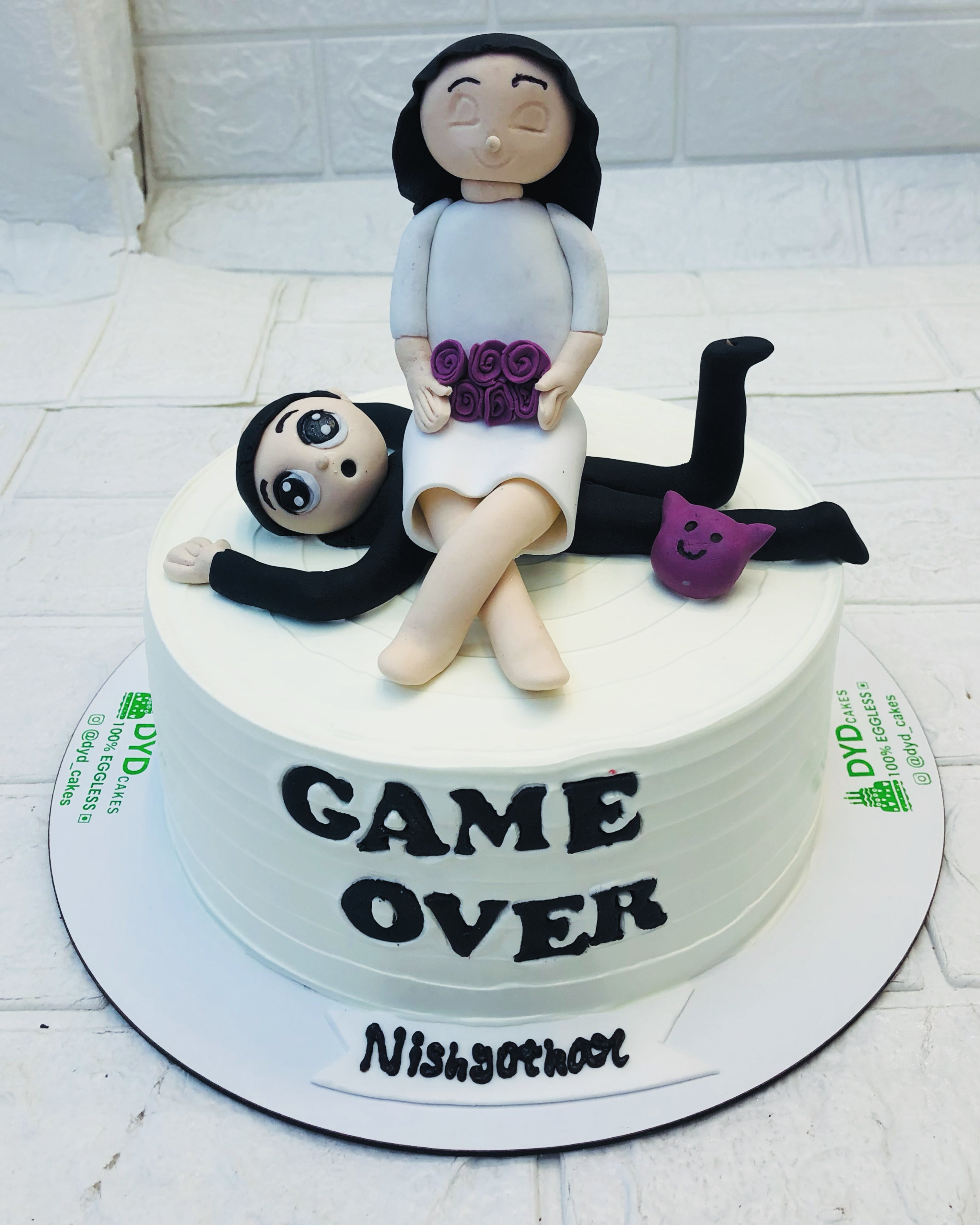 Beautifully designed cake for "Game Over Theme" written on the side of cake and Cute Couples sitting on other, perfect for engagement celebration.