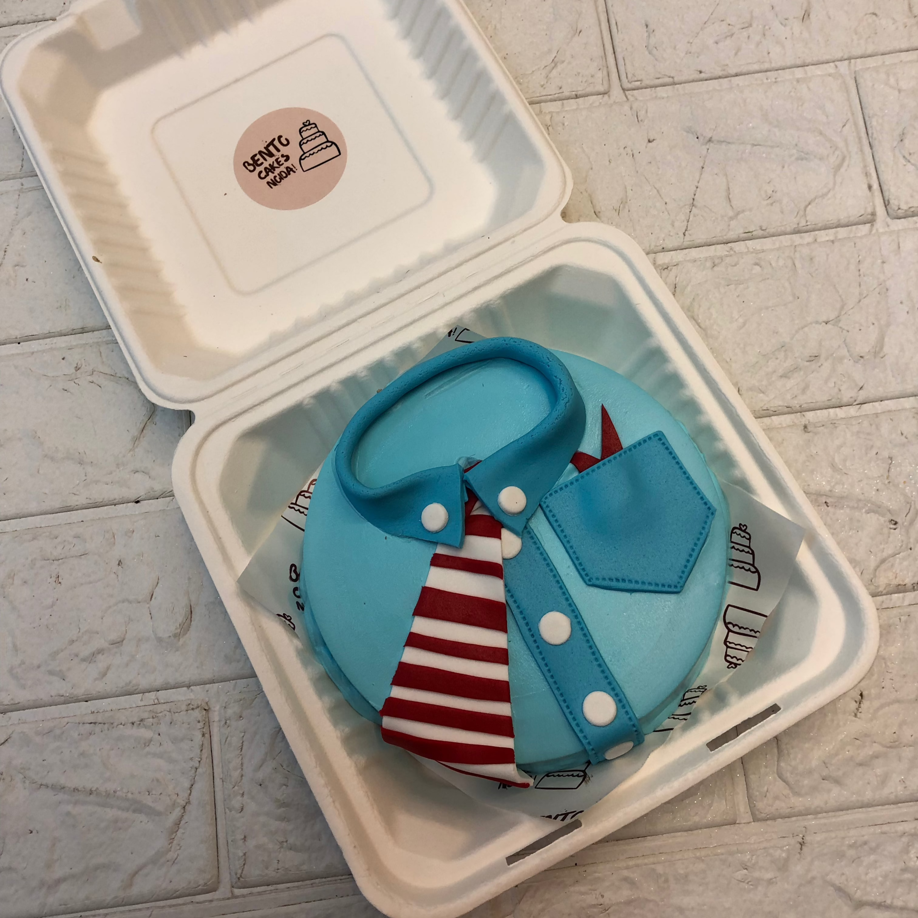 A whimsical dressed in a tie and Blue shirt, elegantly presented in a decorative box.