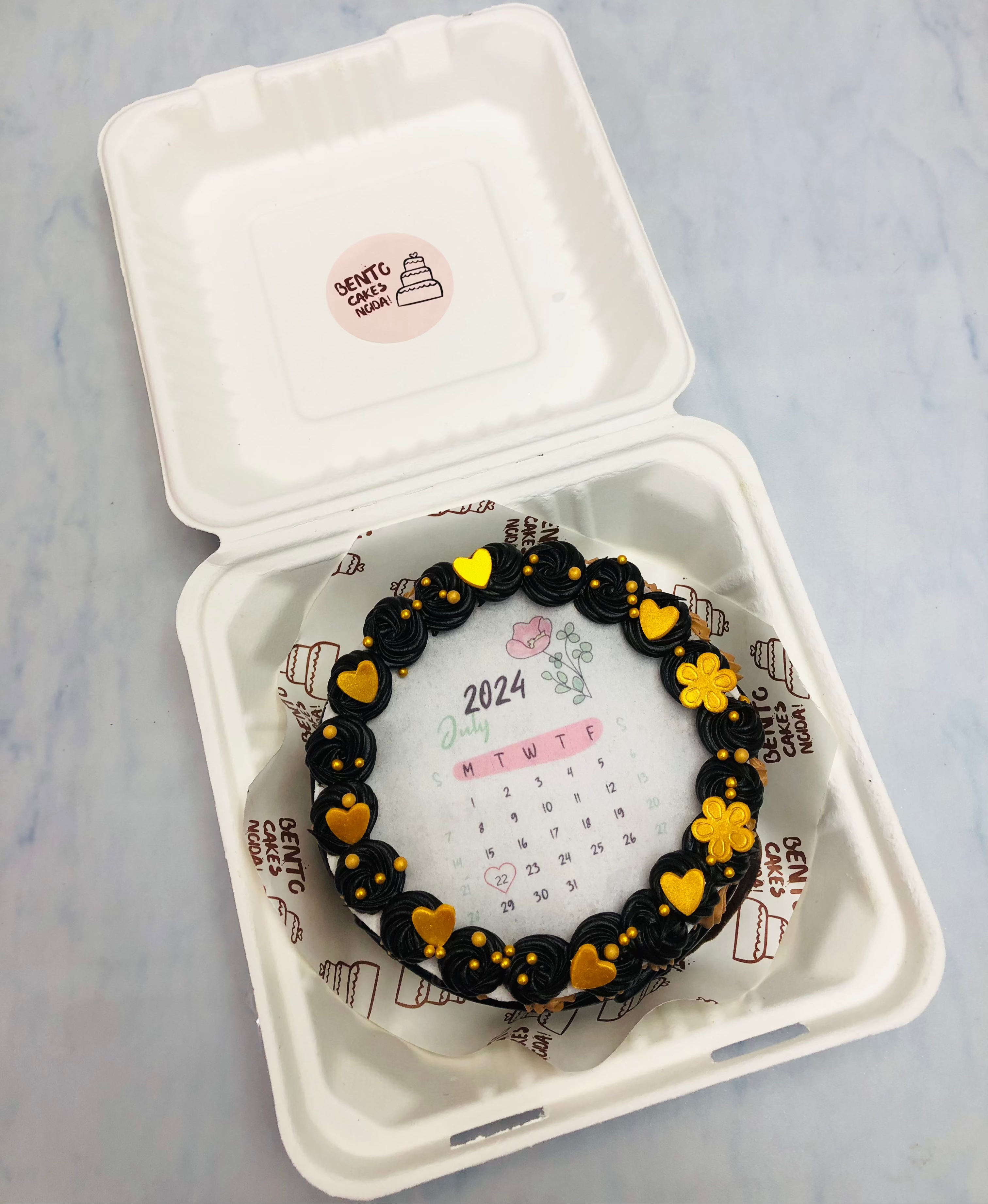 A black truffle fire bento cake with calendar theme.