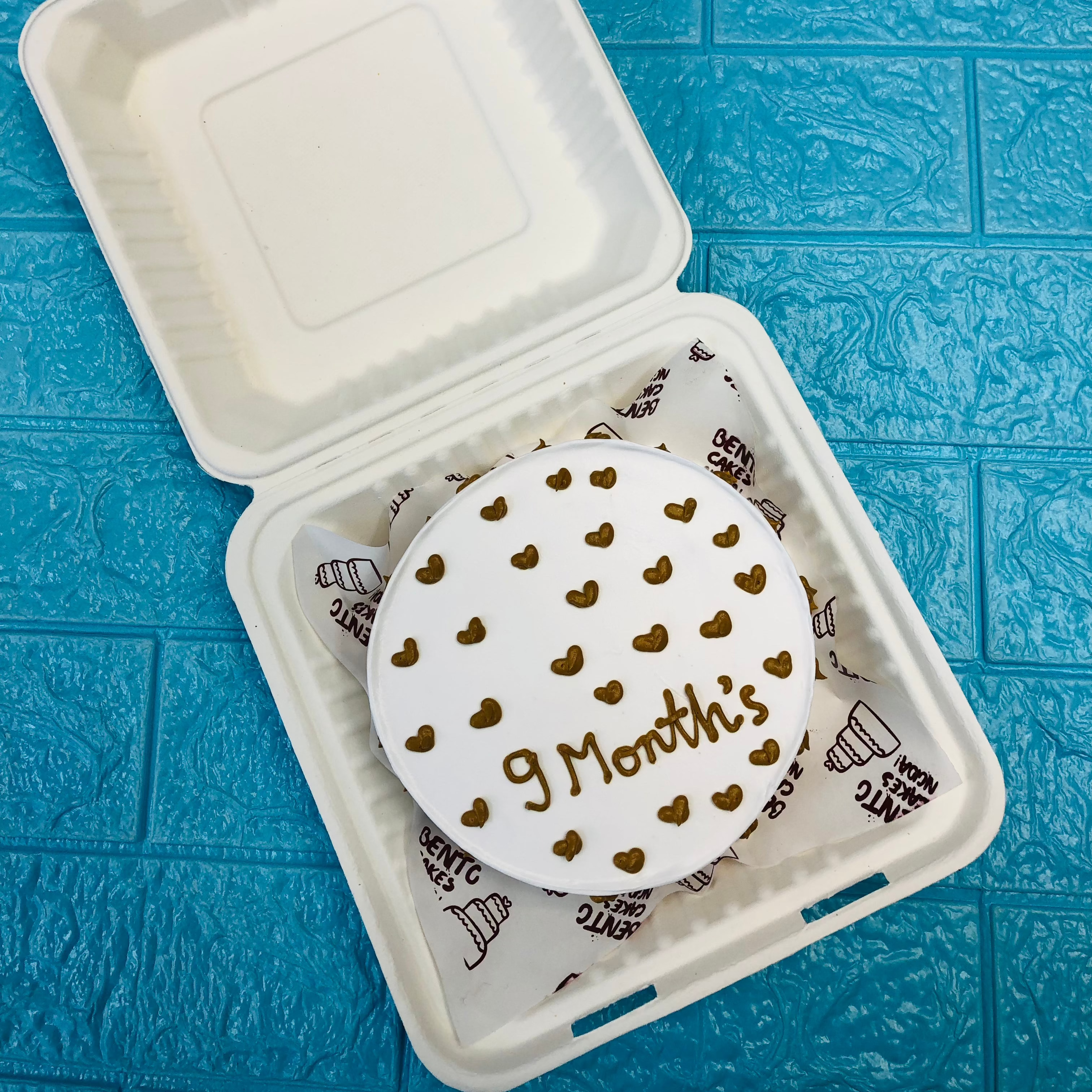 A white bento cake full of brown little hearts.