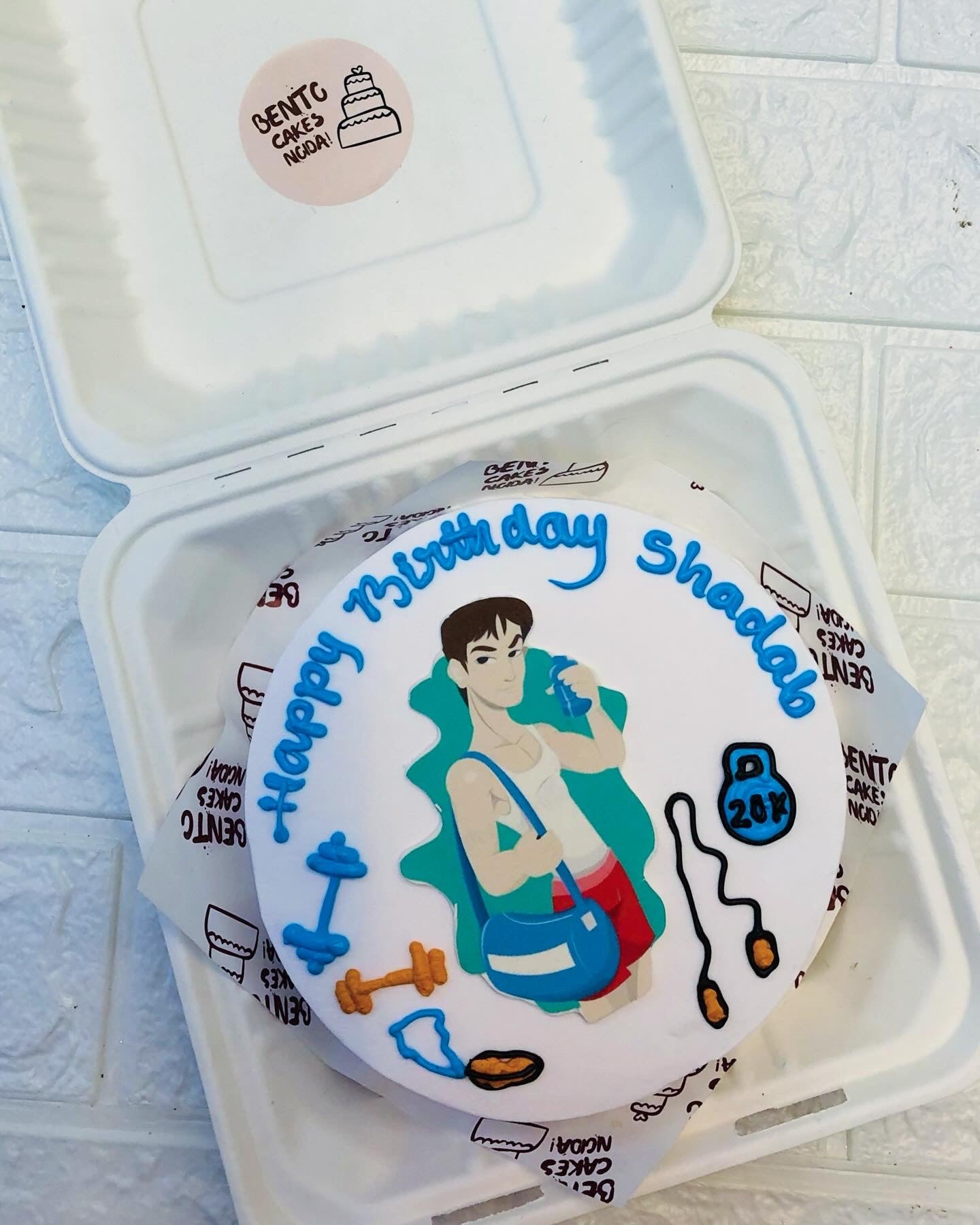 A white bento cake designed for gym lovers professional with their kit.