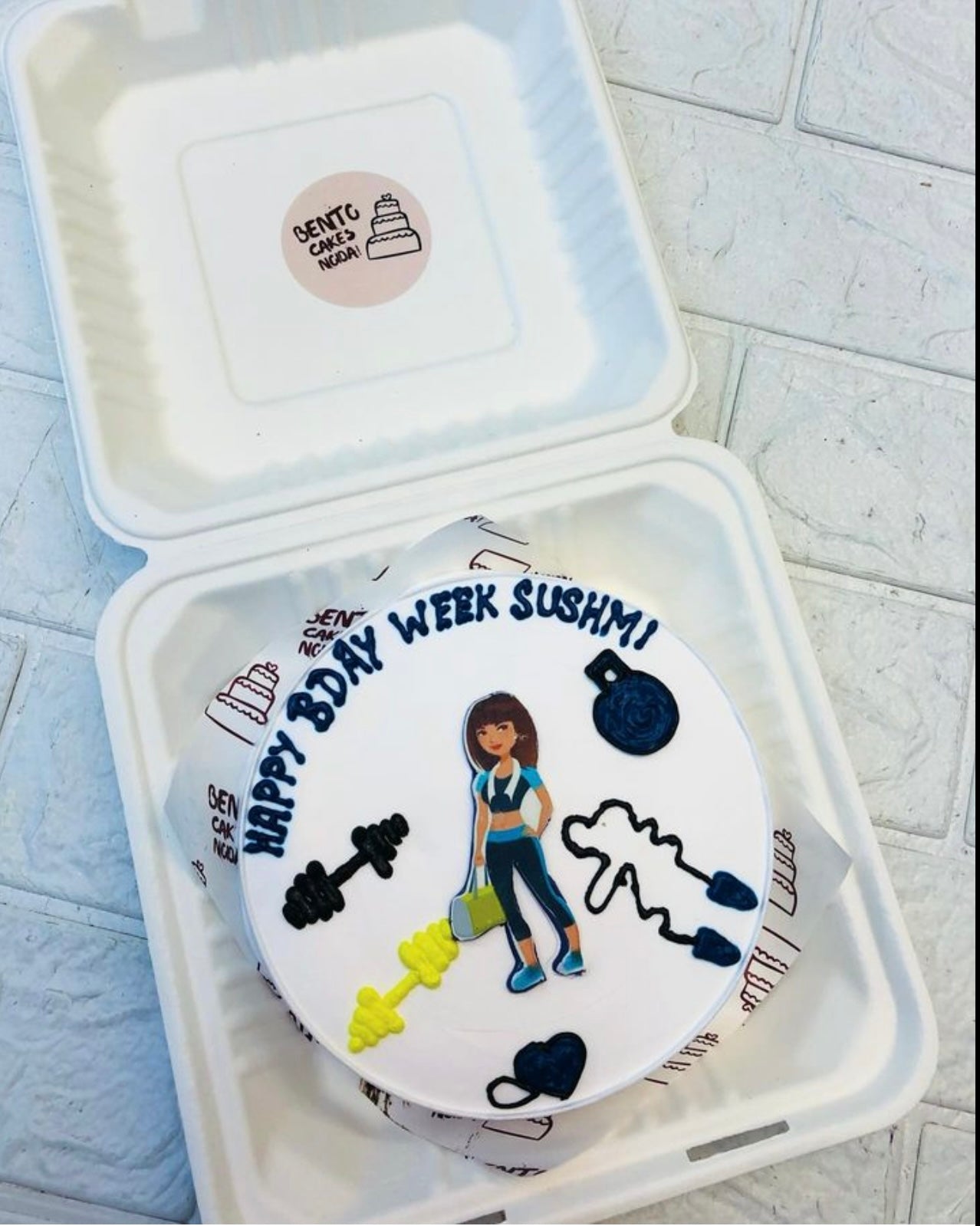 A white bento cake for gym lovers girl with their gym kits.