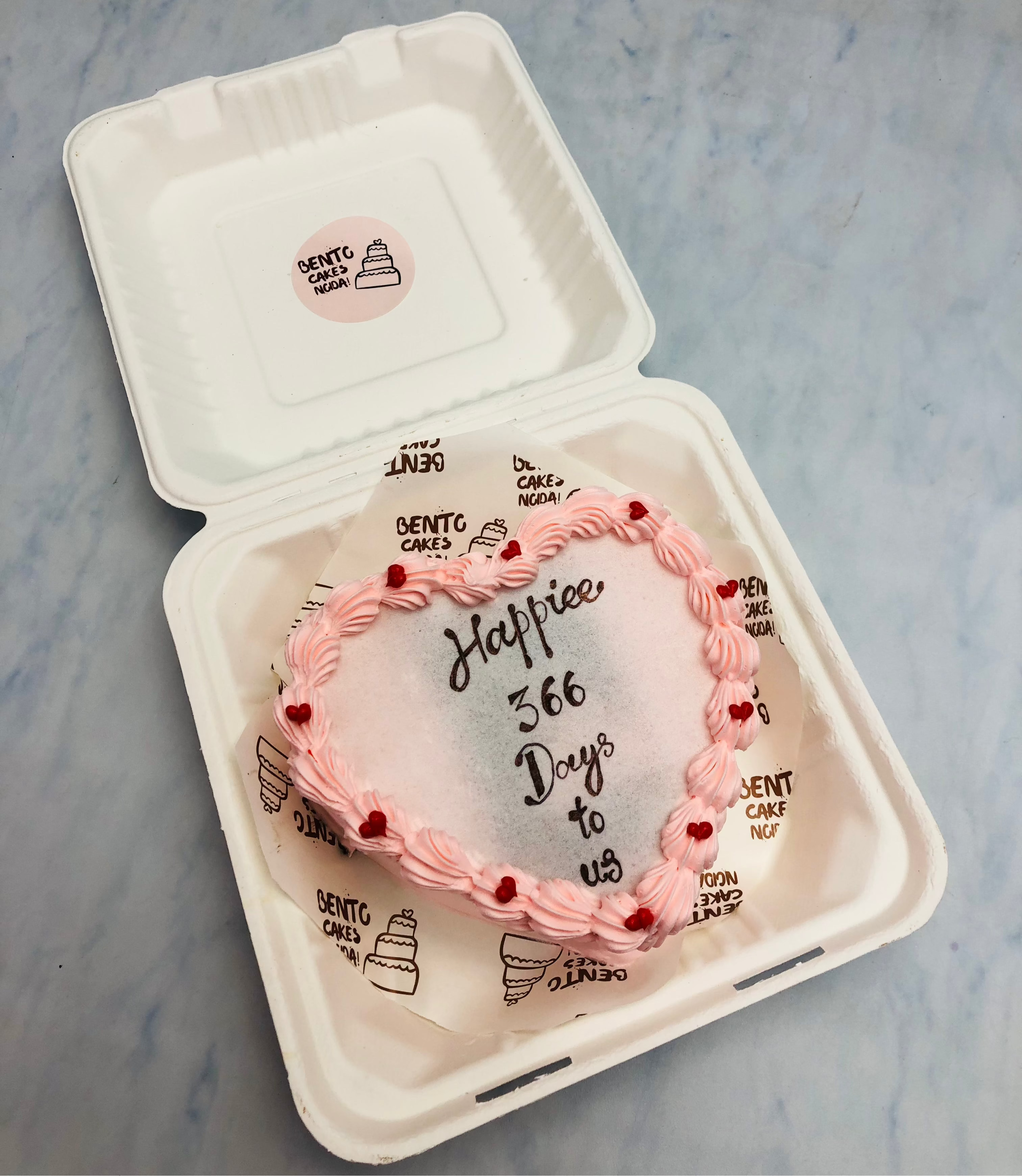 A light pink heart shape fire bento cake is designed for 1 year anniversary.