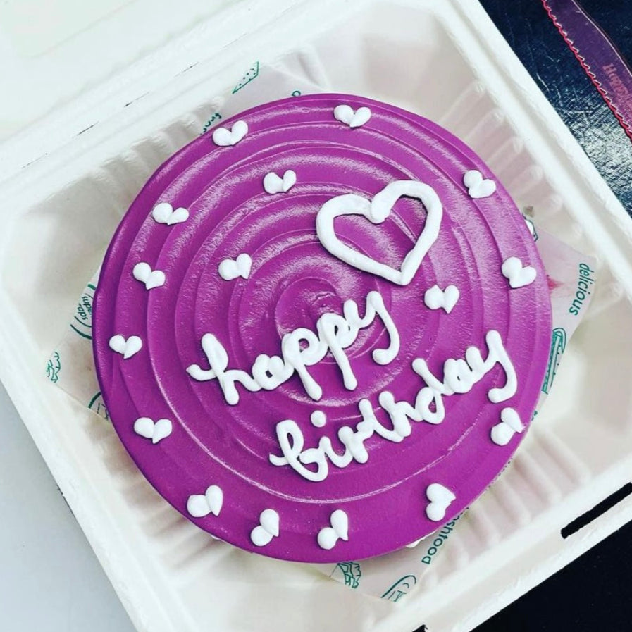 Purple color bento cake is designed with white hearts design and happy birthday message on the top of cake.