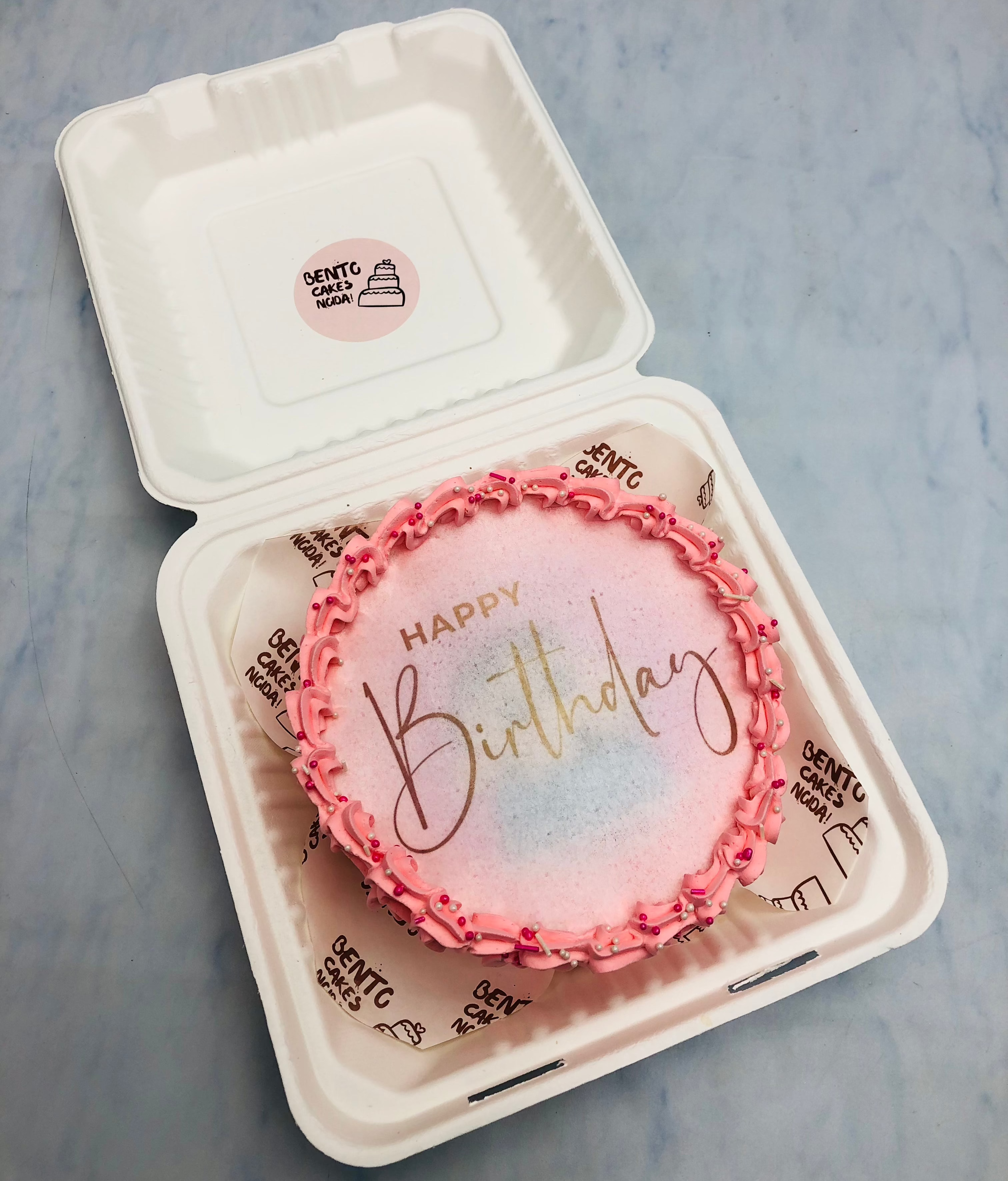 A light pink decoration on Happy Birthday theme fire bento cake.