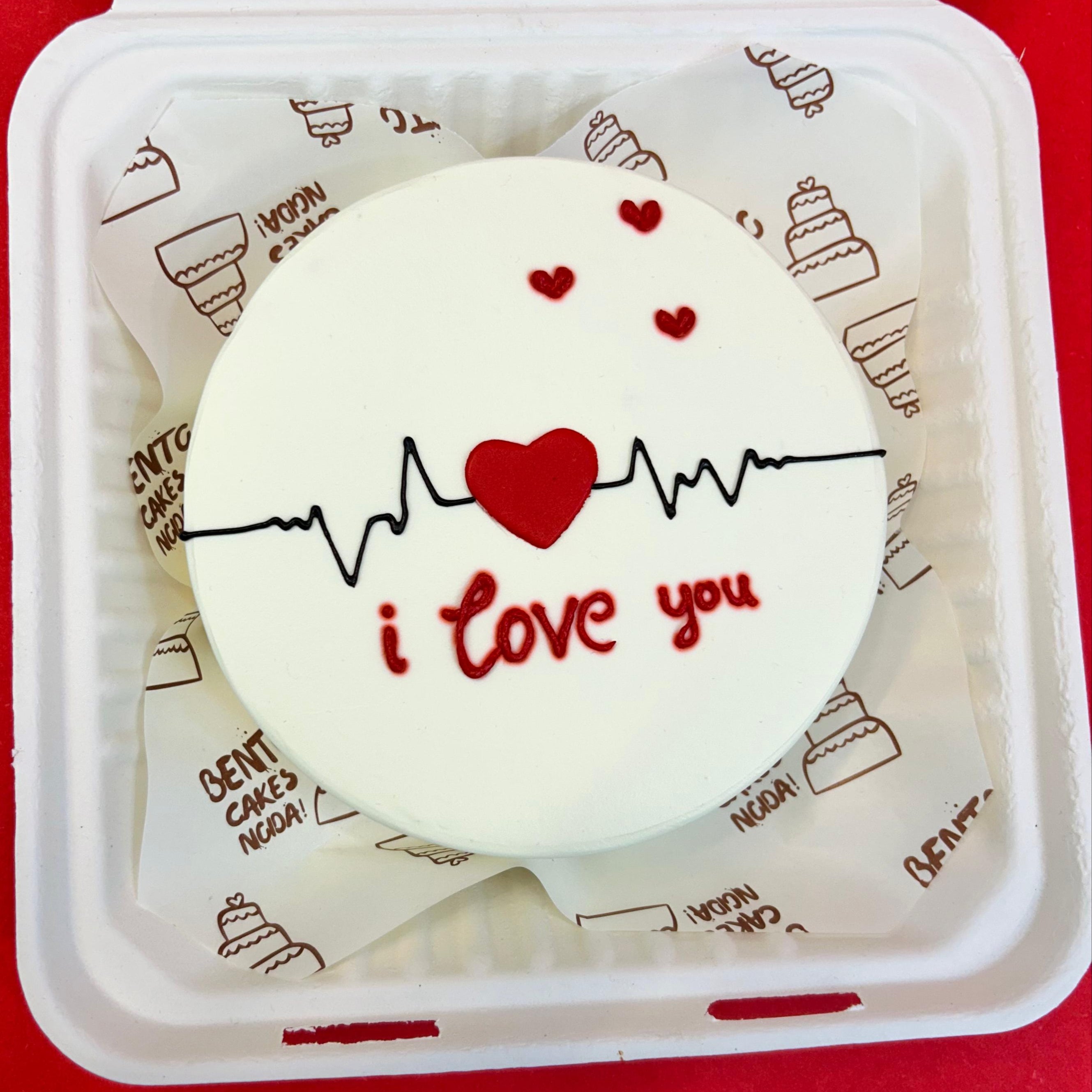 A white box featuring a heart-shaped cookie on top, adorned with the text "I love you" with front view.