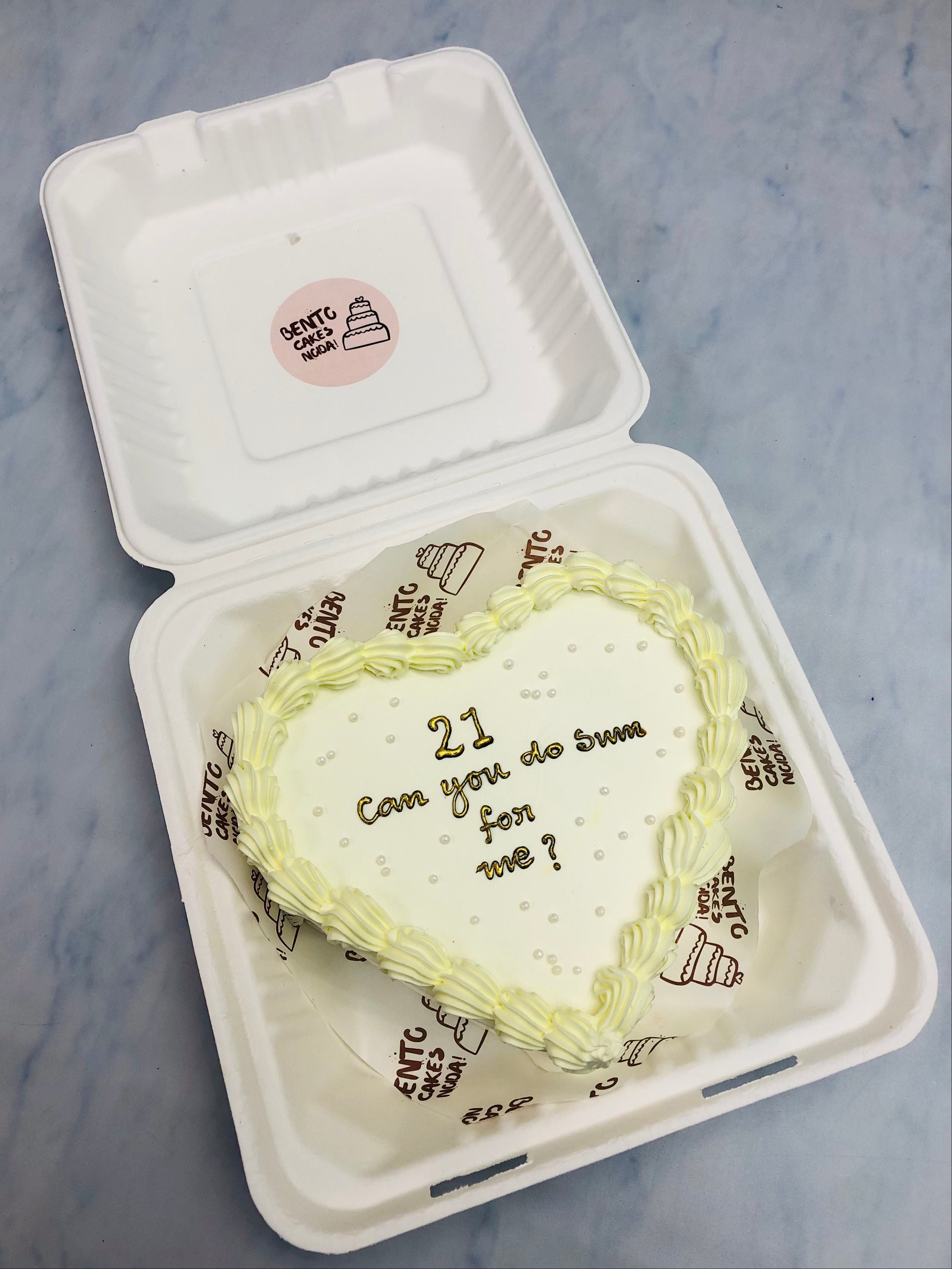 An offwhite heart design cake decorated with white truffle and white sprinkles.