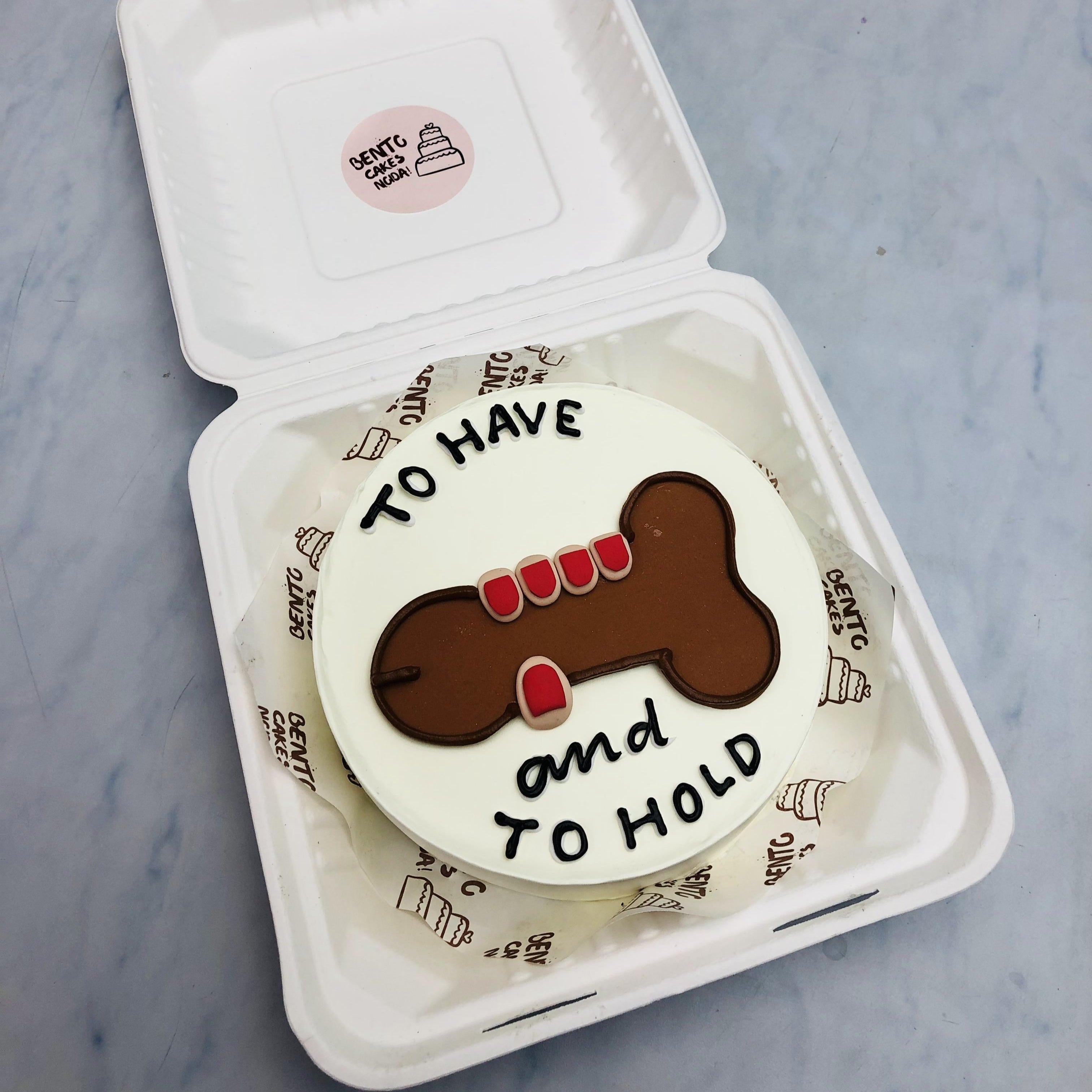 A white bento cake with a dick holded hand design and a text wrieen on the cake.