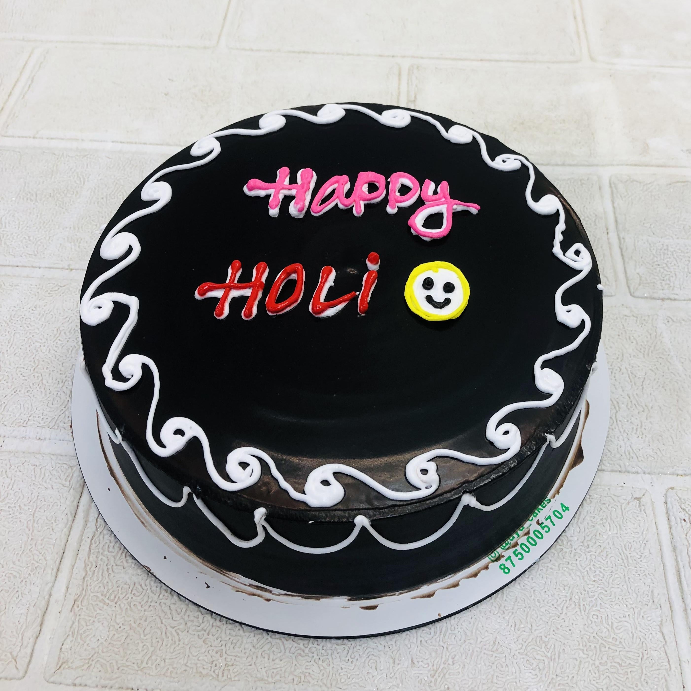 Black chocolate cake beautifully designed with "Happy Holt" Text and Cute Smiley.