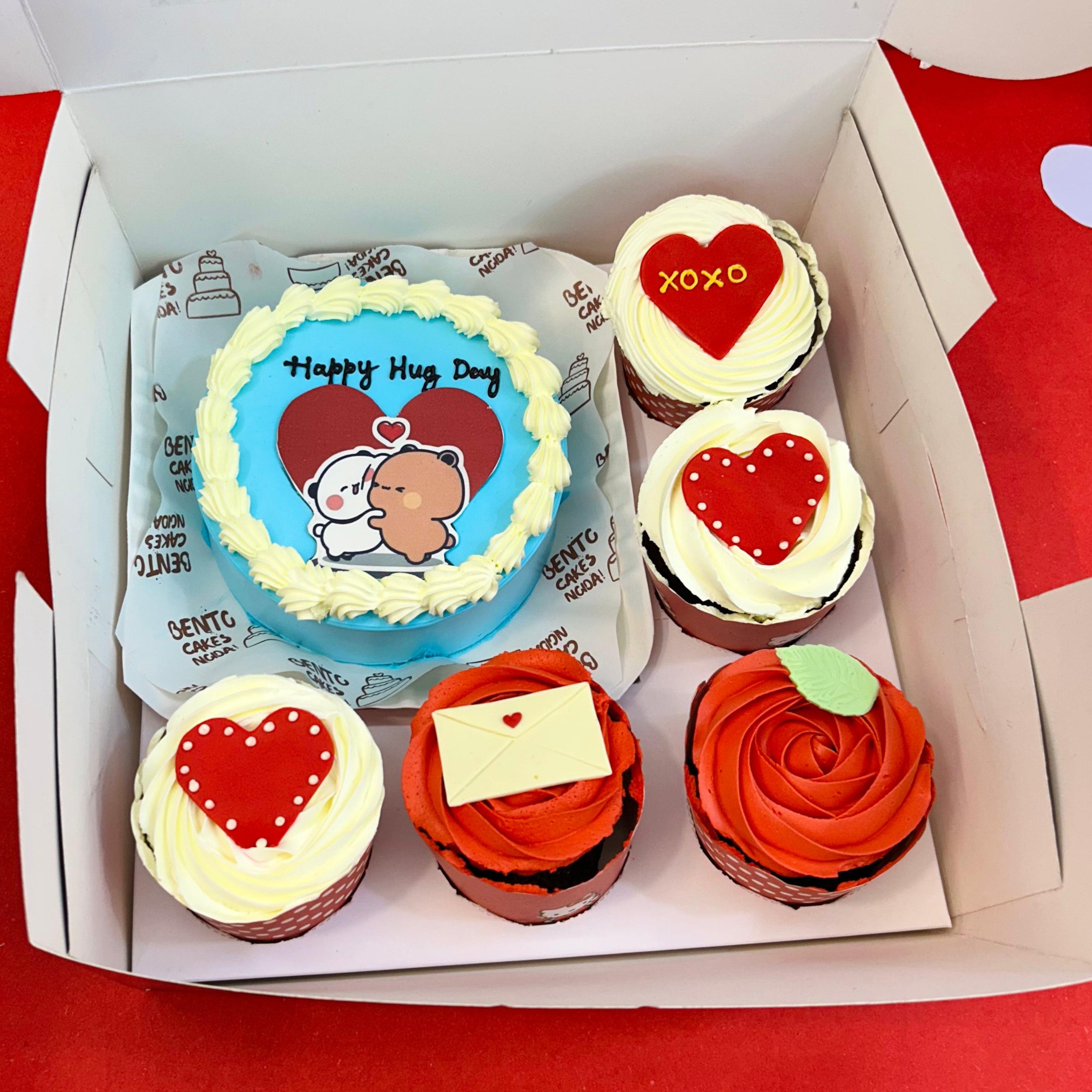 A heart-decorated box of cupcakes, complemented by a bento combo cake for a delightful Hug Day treat.