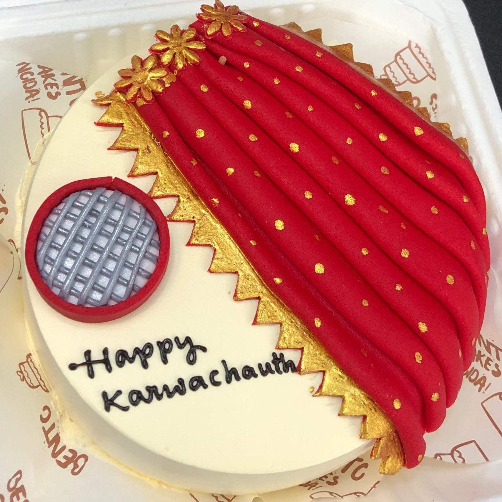An off white bento cake with a fondant red shareedesign and a net design for Karwachauth festival.