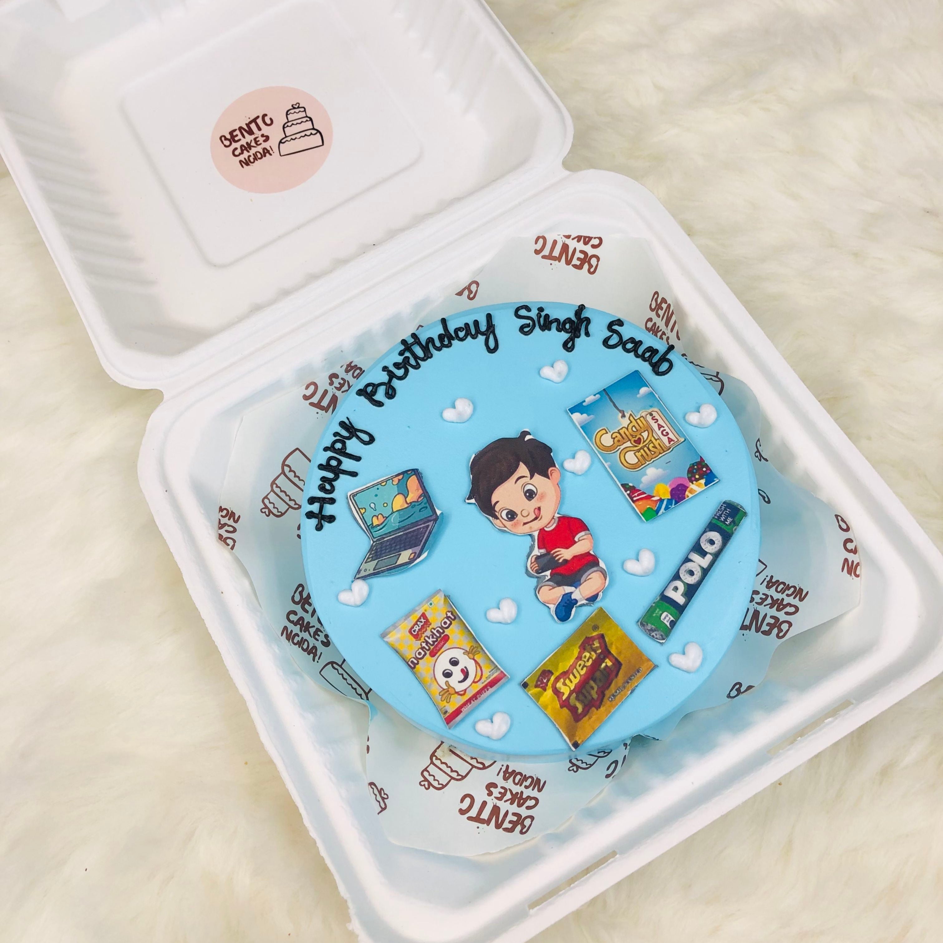 A beautifully decorated birthday cake inside a bento box, emphasizing its colorful icing and celebratory theme.